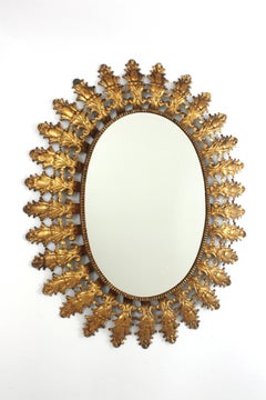 Specchio ovale a raggiera con fogliame spagnolo in ferro dorato, anni '50