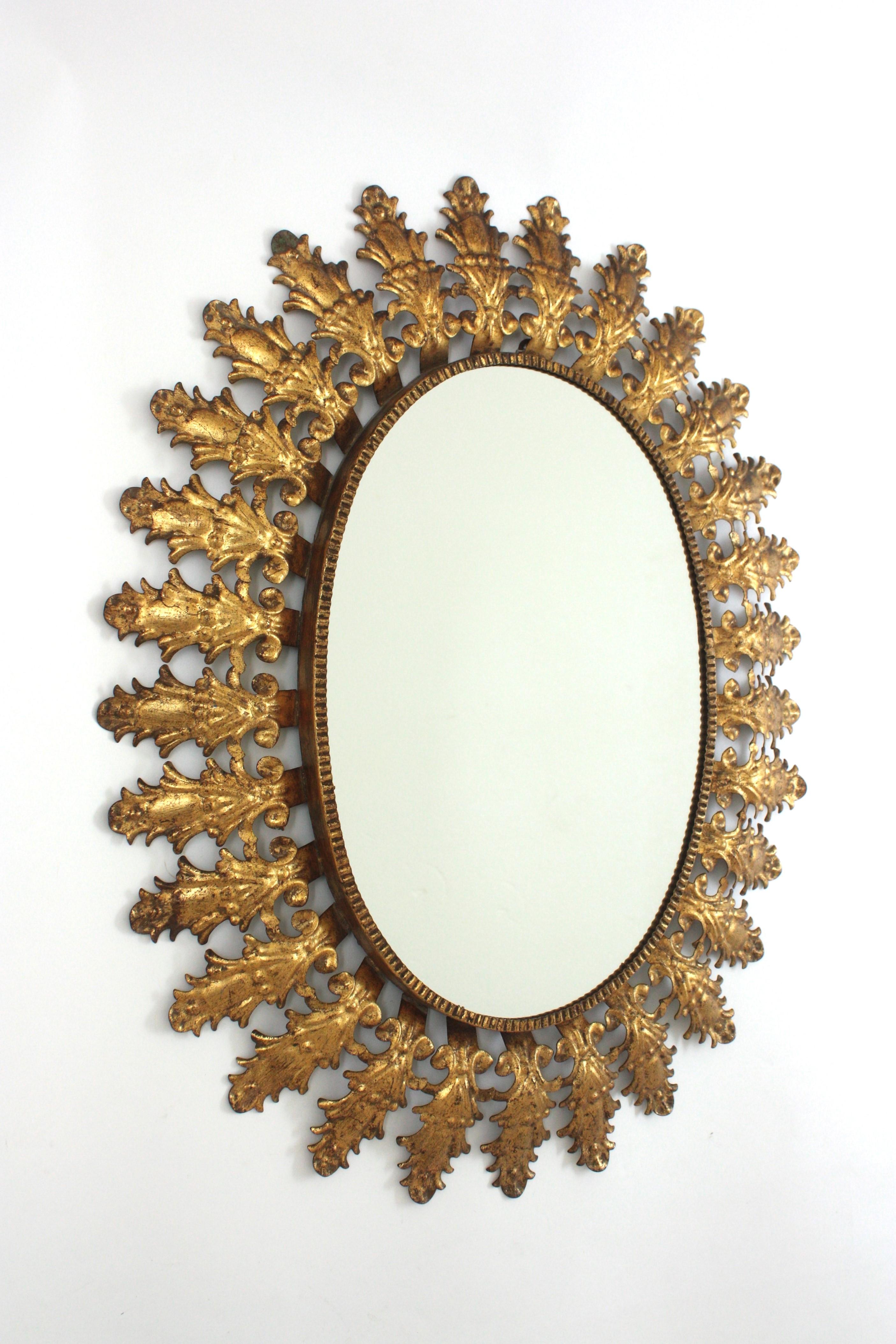 Hollywood Regency Miroir solaire ovale en fer doré avec feuillage espagnol, années 1950 en vente