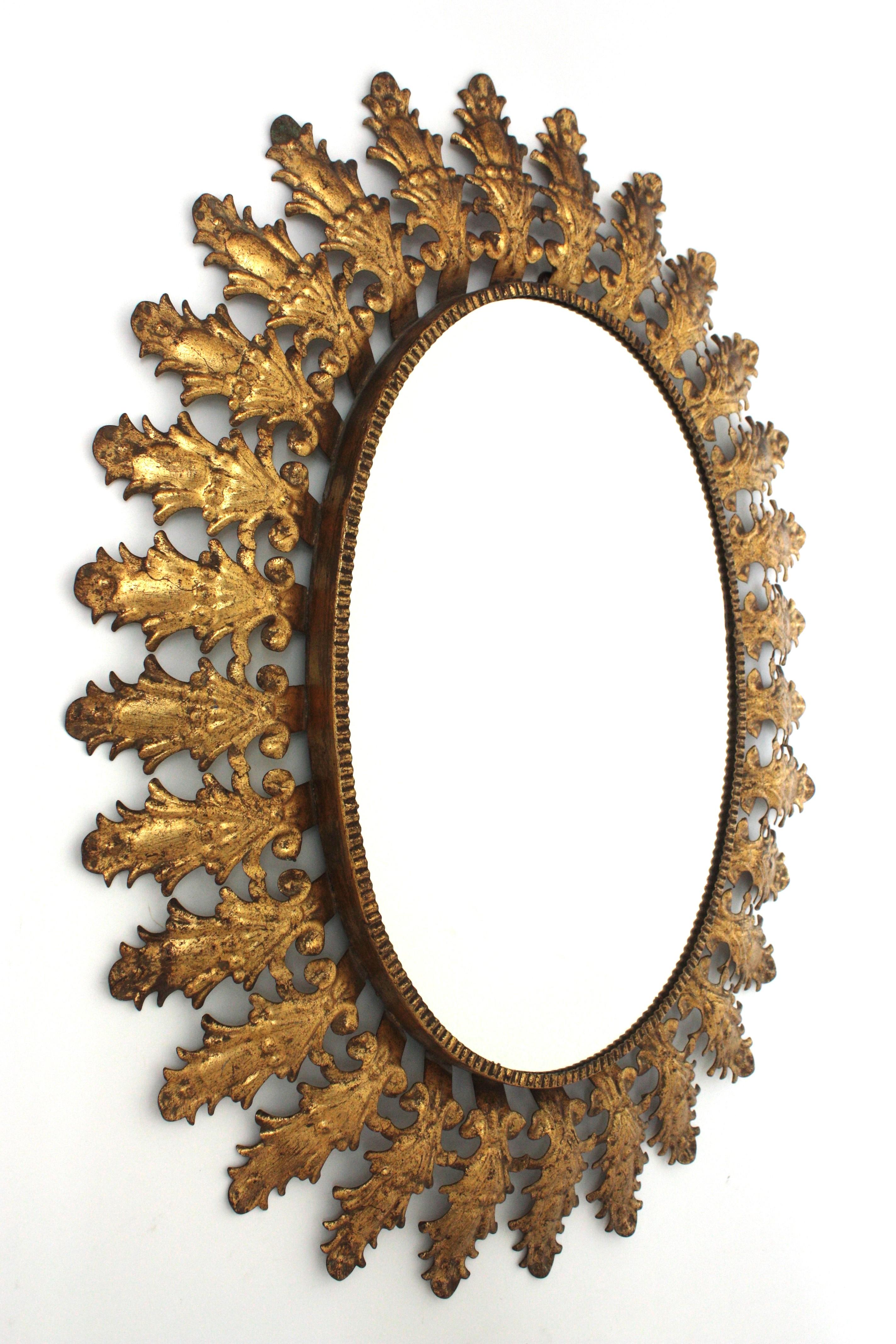 Doré Miroir solaire ovale en fer doré avec feuillage espagnol, années 1950 en vente