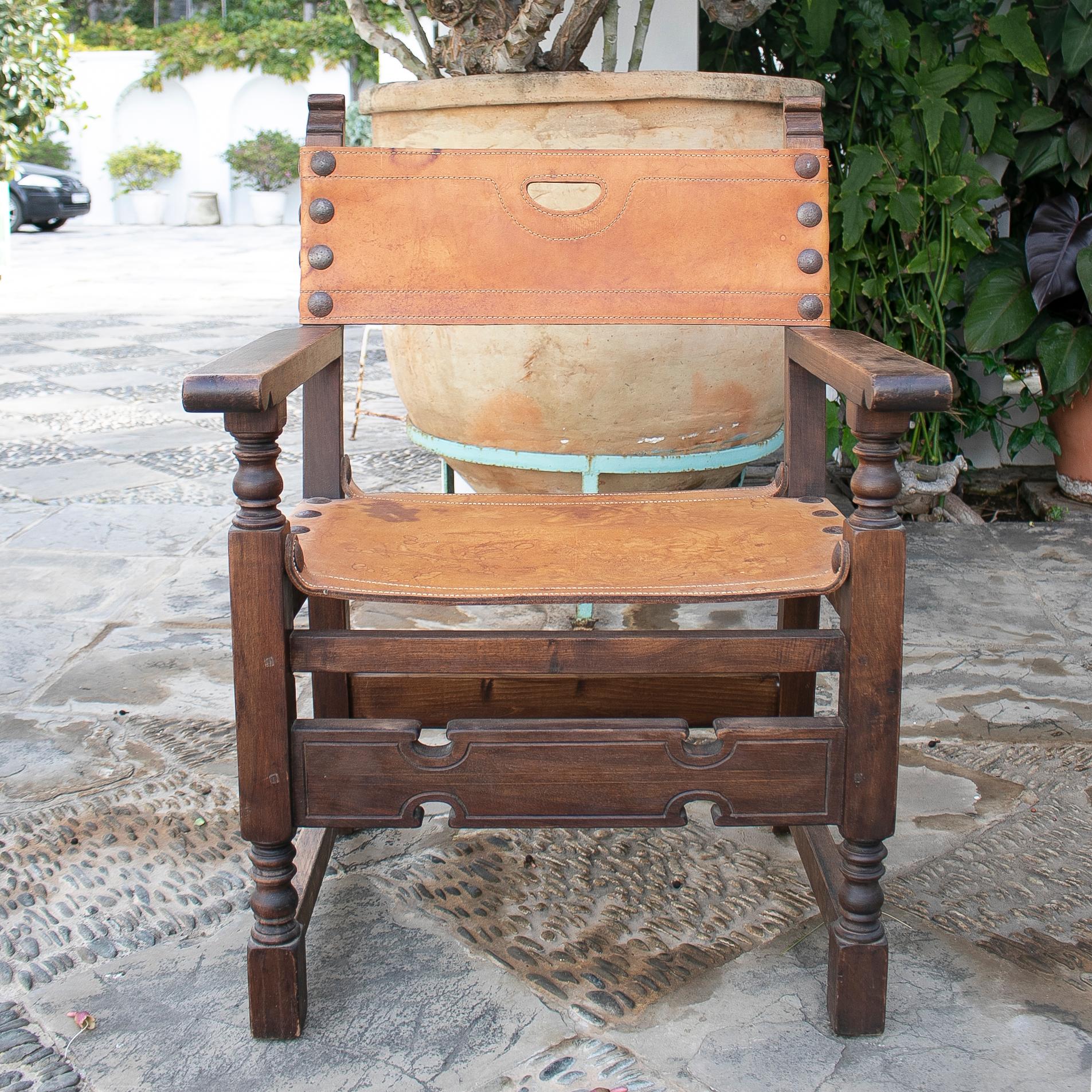 fauteuil de moine en bois sculpté et cuir des années 1920.