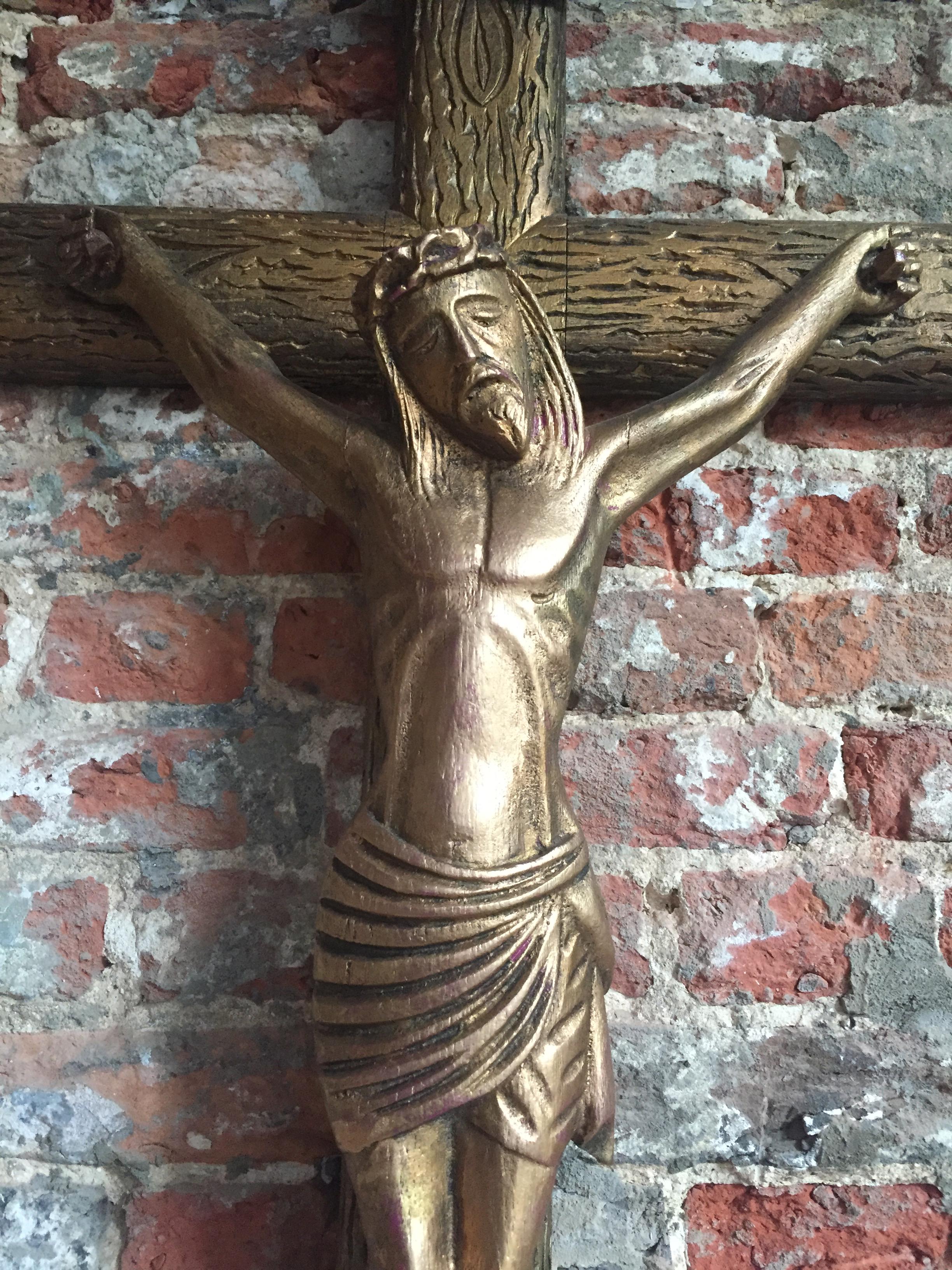 Spanish hand carved oak crucifix. Warm stylised depiction of Jesus in the style of Gaudi, circa 1920. Painted in gold.