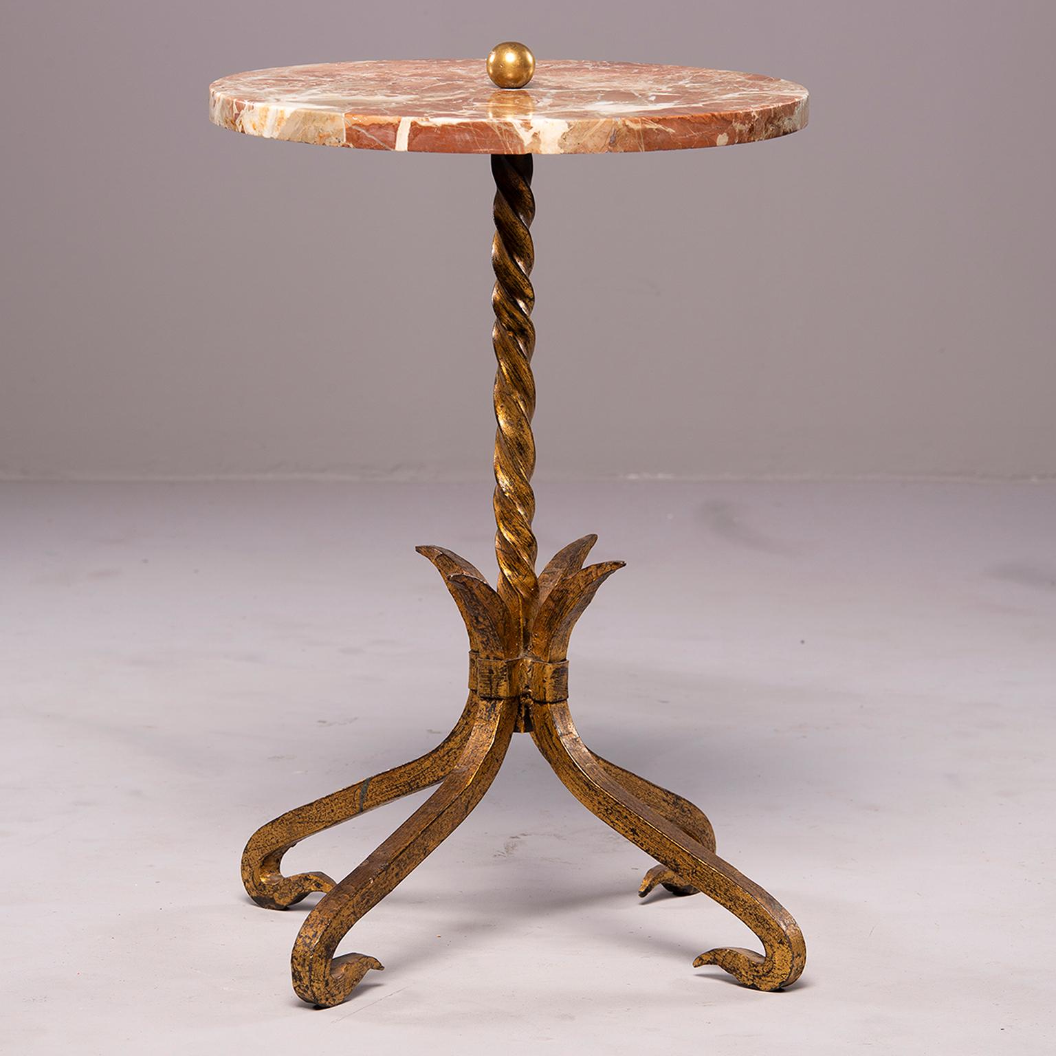 Spanish side table has gilded iron base with four curved feet and twisted centre support rod topped by a round marble tabletop, circa 1930s.
