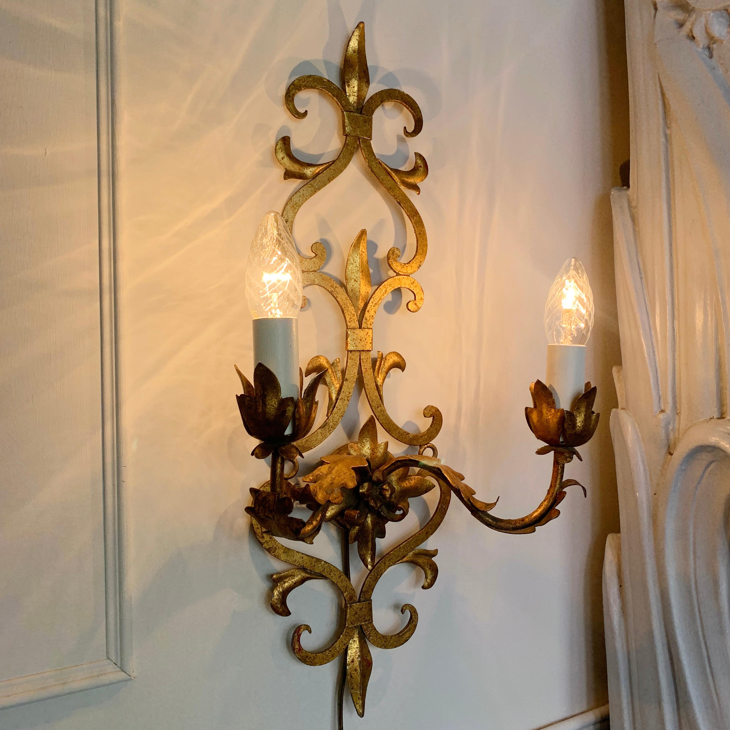 Spanish Baroque wall light, in forged gilt Iron, with applied leaf detailing, dating from the 1950's. 

Measures: Height 54cm x width 28cm x depth 14cm (rose 7cm).