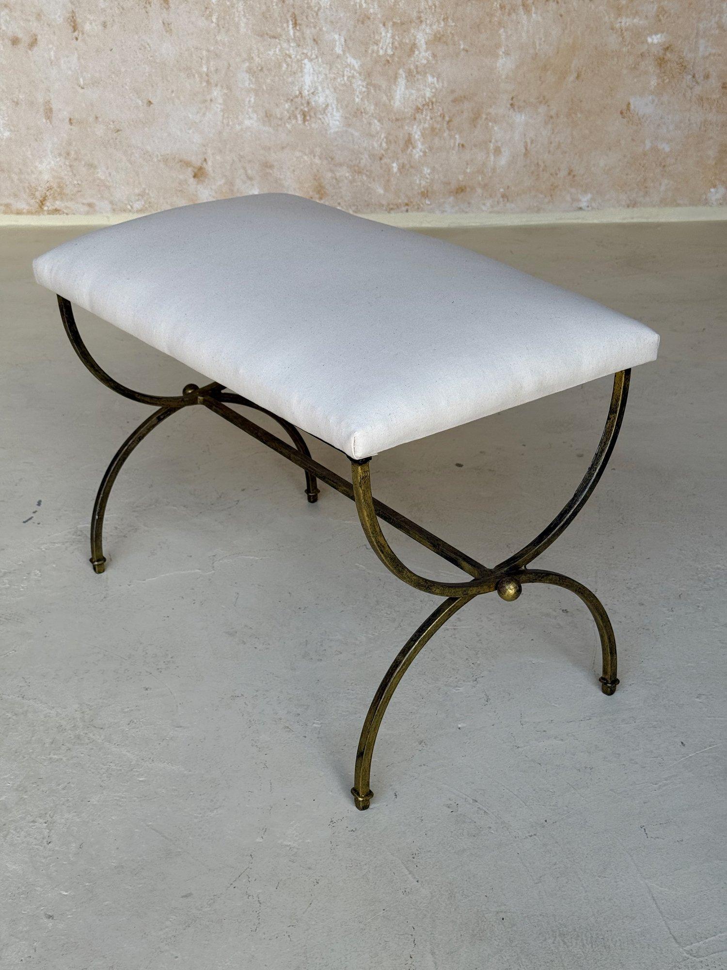This lovely iron bench was recently hand crafted by skilled European artisans using traditional iron-working techniques and materials. It features gracefully curved legs and a central stretcher with a decorative central ring detail and spheres at