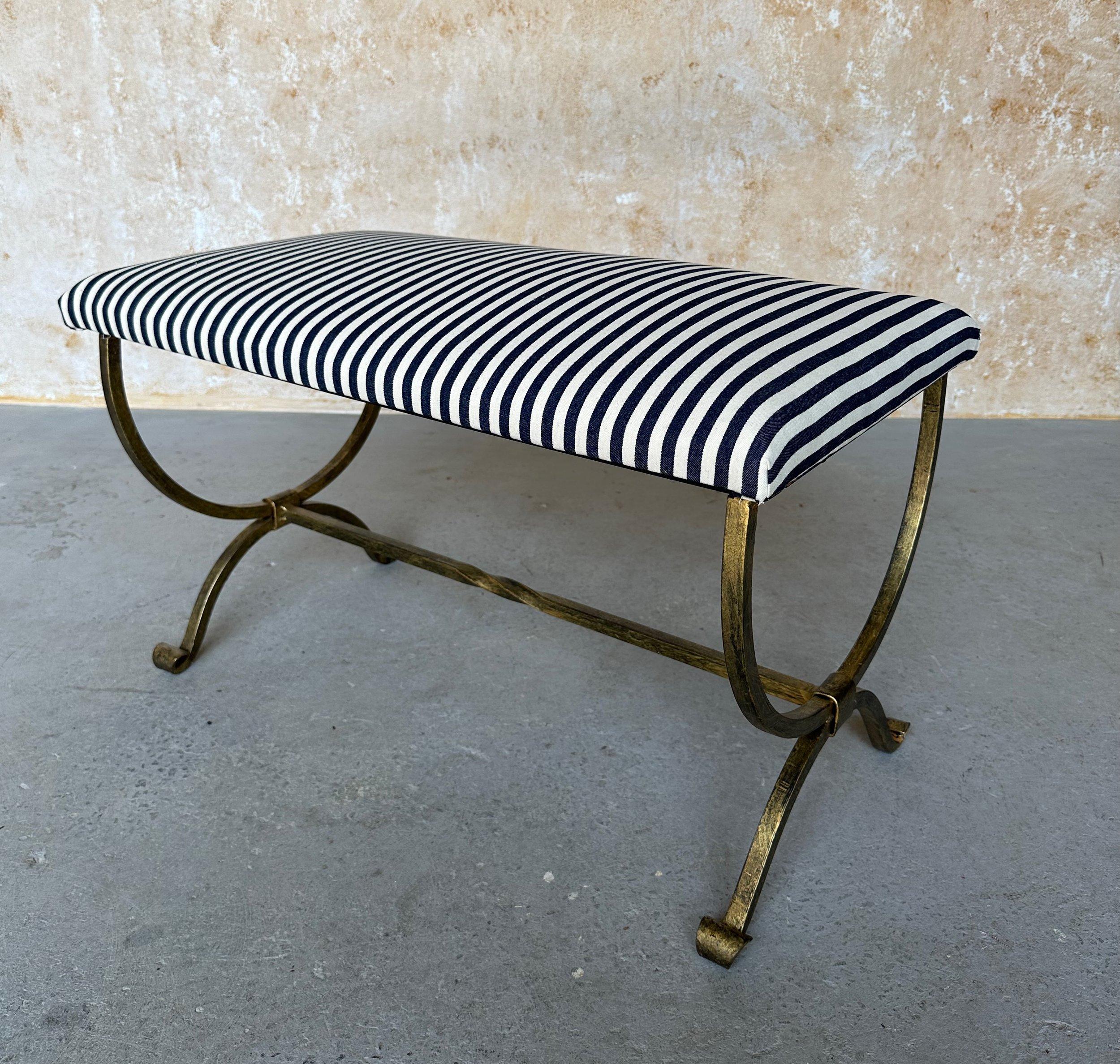 Ce magnifique banc en fer doré espagnol a été récemment fabriqué à la main par des artisans européens qualifiés. Il se compose d'une base en fer forgé à la main, de pieds gracieusement enroulés et d'un brancard avec une torsion centrale décorative.
