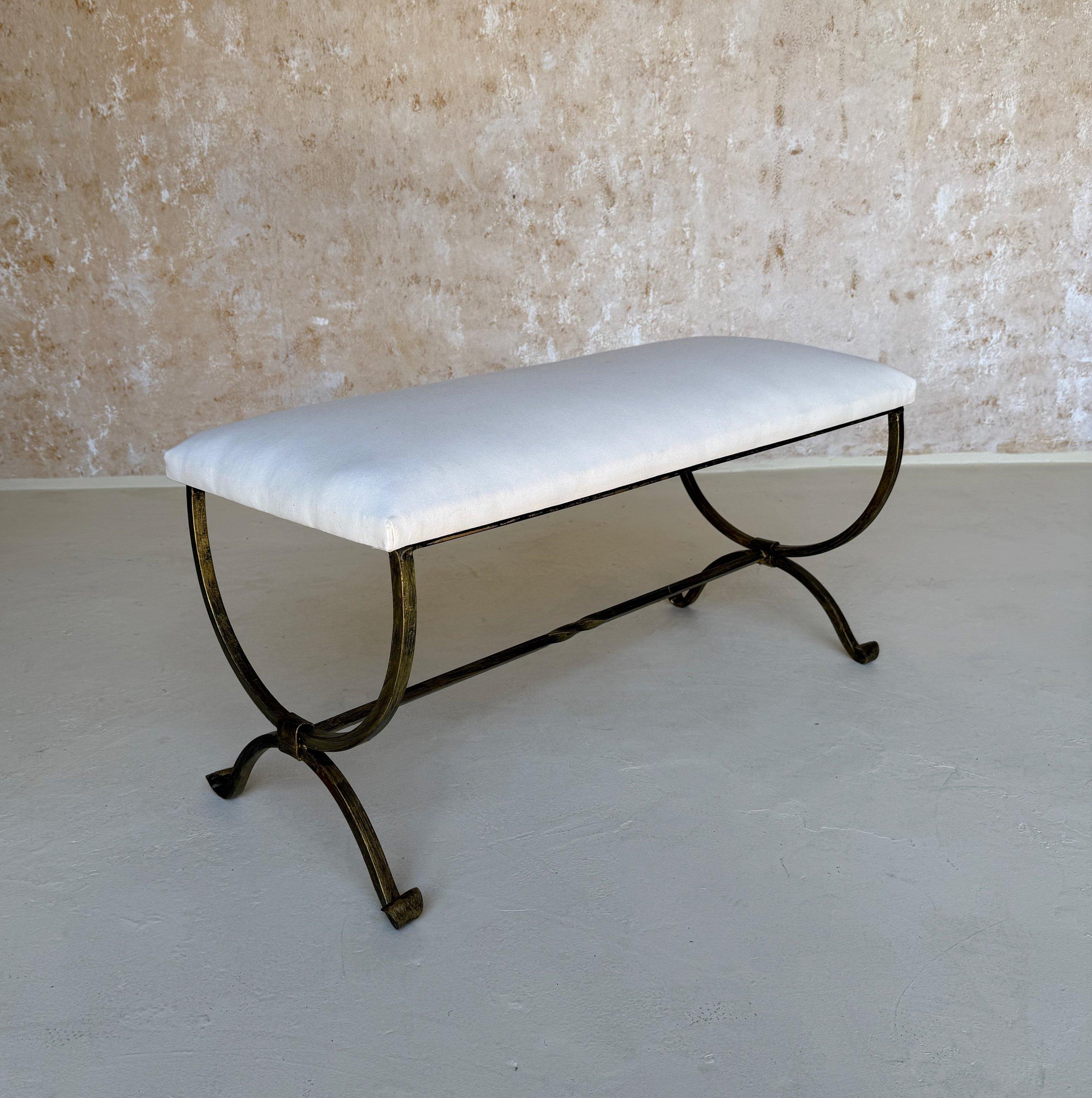 Ce magnifique banc espagnol en fer doré a été récemment fabriqué à la main par d'habiles artisans européens. Il se caractérise par des pieds gracieusement incurvés, des pieds à volutes et un brancard avec une torsion centrale décorative. Fabriqué à