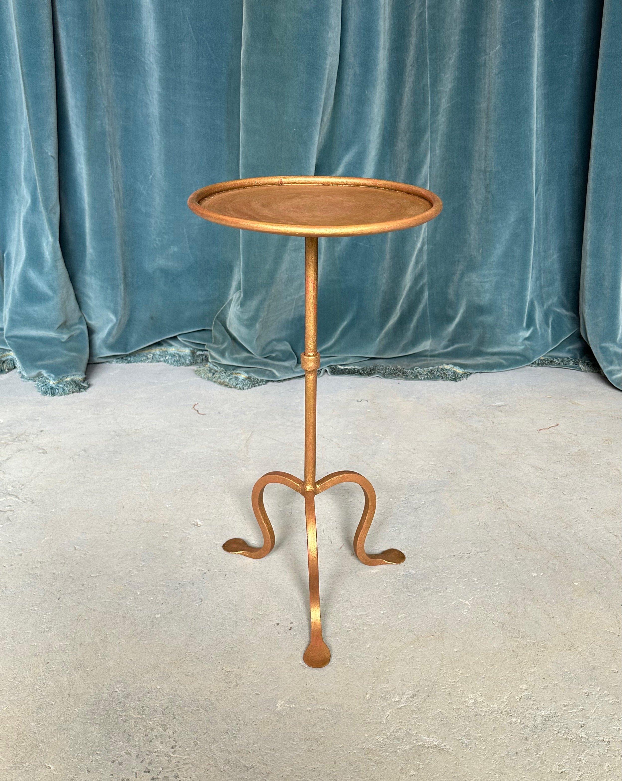 Dieser hübsche spanische Eisentisch, der auf einem unserer Lieblingsdesigns im Vintage-Stil basiert, wurde vor kurzem nach unseren Vorgaben angefertigt und weist eine von Hand aufgetragene Goldvergoldung mit roten Untertönen auf. Der Stiel ist mit