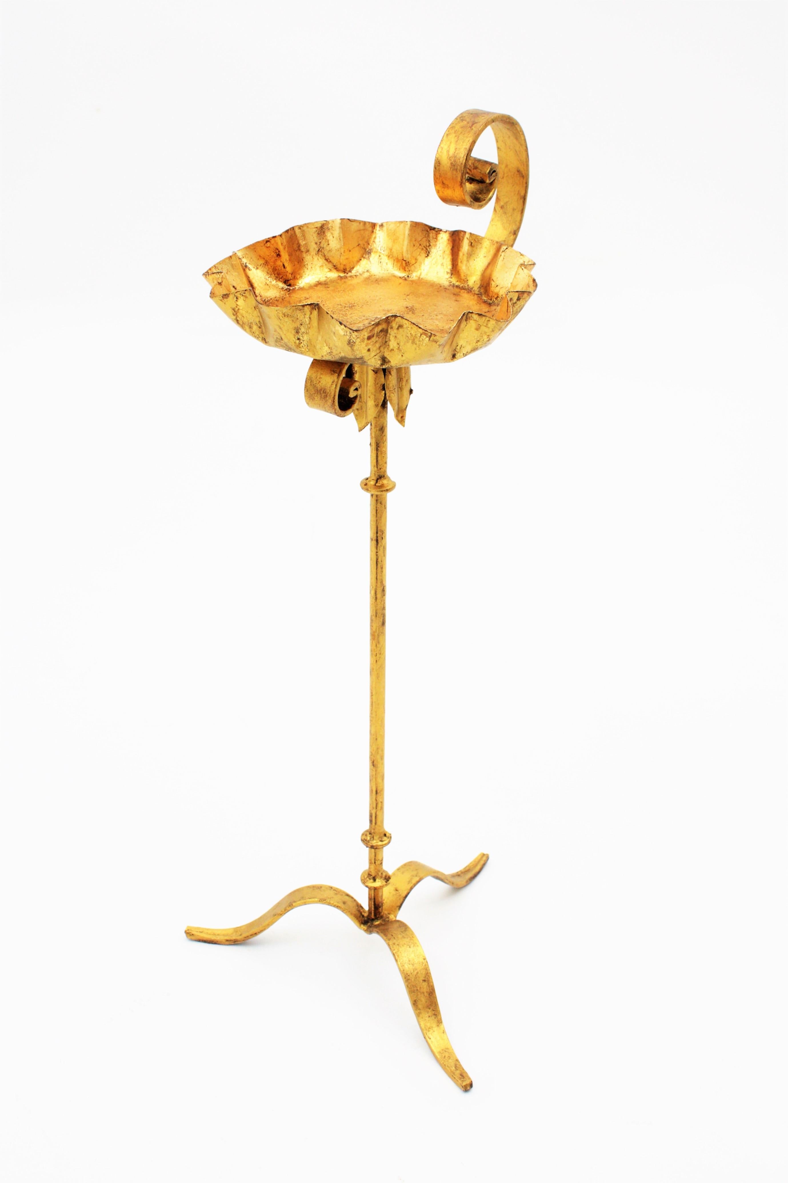 Wrought gilt iron floor ashtray, tripod stand or pedestal in Gothic style, 1930s
An stylish hand-hammered iron Gothic style standing ashtray with scroll detailing and wavy edged top. It has a nice patina with gold leaf finish.
This piece is in