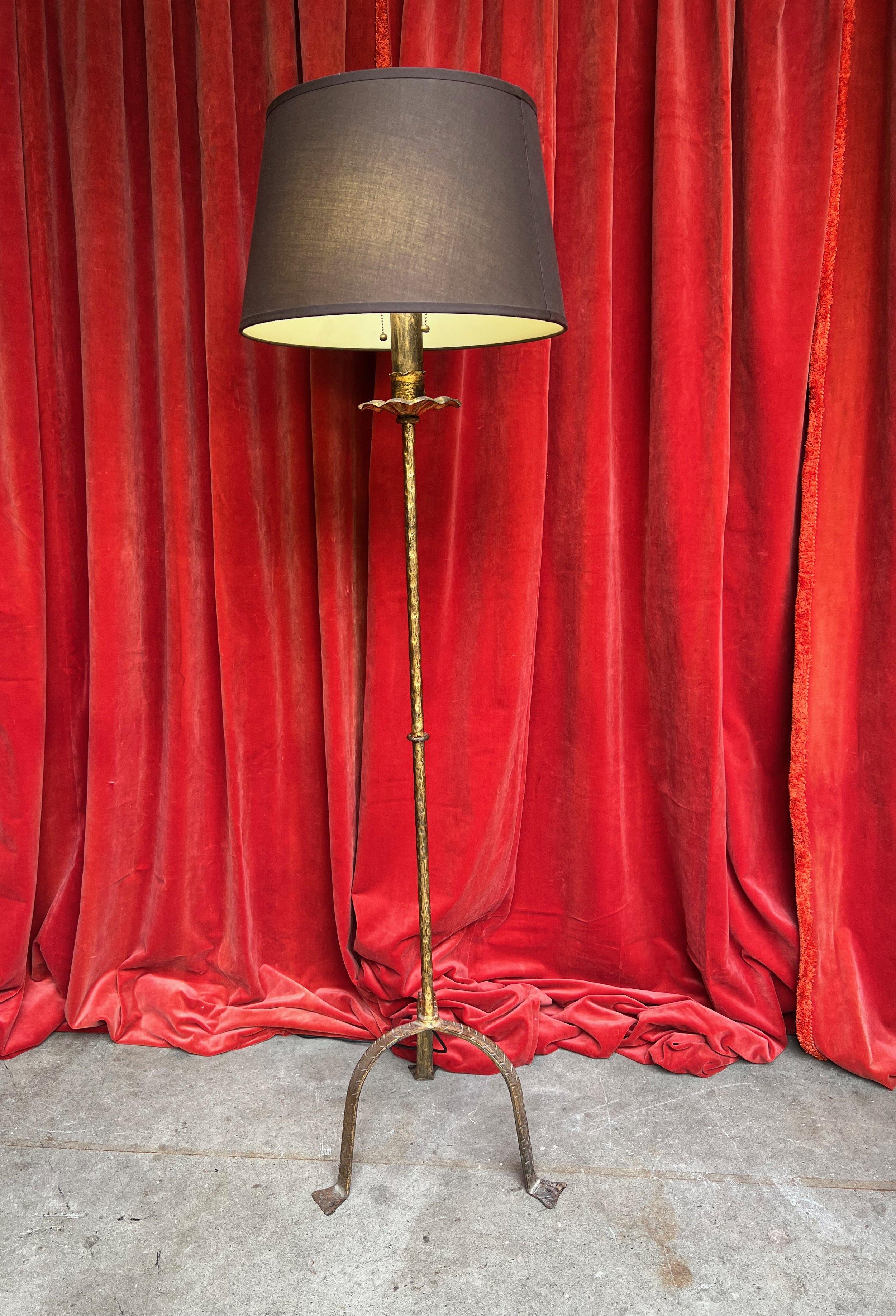This classic iron floor lamp is a stunning addition to any living space, featuring a hand-patinated gilt finish that adds a touch of sophistication. Skillfully handmade in Spain during the 1950s, this lamp boasts exceptional quality and timeless