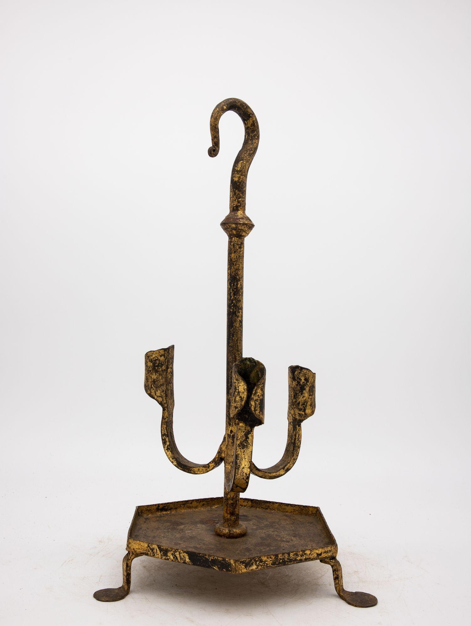 This enchanting 1950s Spanish gilt iron candlestick perfectly captures the tradition of ironwork Spain is known for. Its vintage allure exudes timeless beauty and sophistication. Crafted with meticulous attention to detail, the stand features three