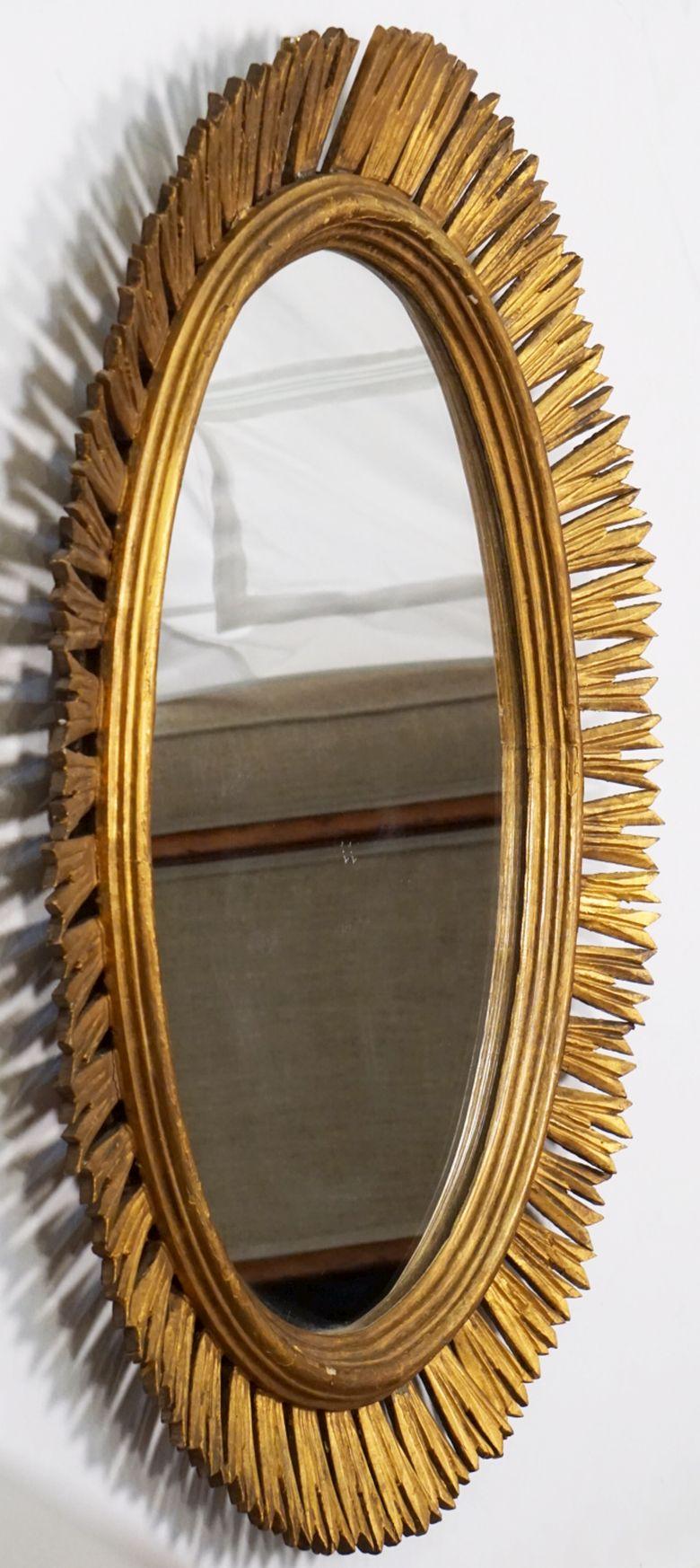 A fine large Spanish gilt sunburst (or starburst) oval mirror featuring an ovoid or elliptical mirrored glass center in moulded frame surrounded by emanating rays.

Dimensions are H 31 1/2 inches x W 24 1/2 inches x D 2 1/4 inches