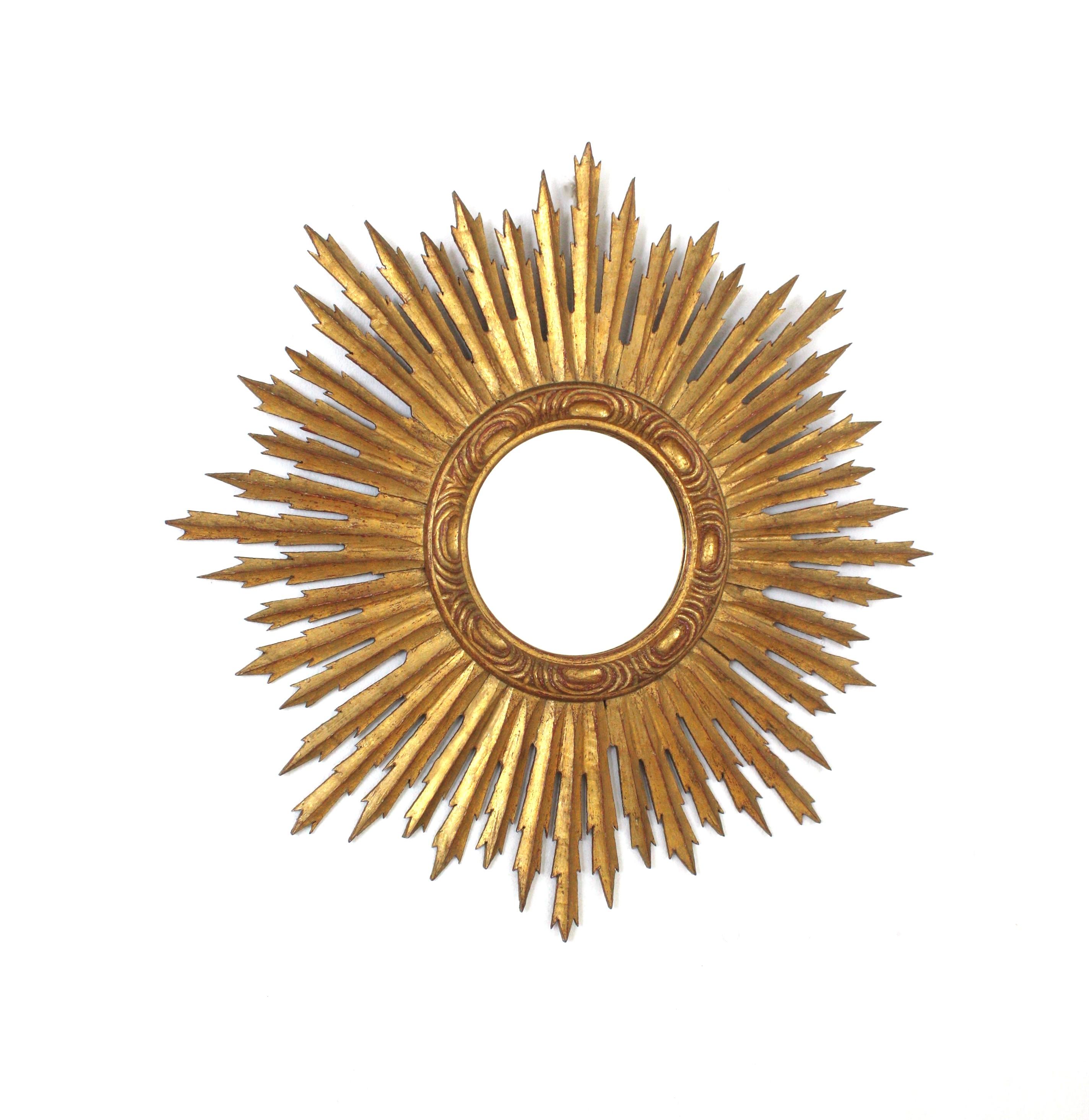 Spanish Baroque Style Giltwood Sunburst Mirror , 1940s
Outstanding Baroque style carved giltwood sunburst mirror with gold leaf finish. 
This gorgeous starburst /sunburst mirror has a frame comprised by rays in different sizes and a ring frame