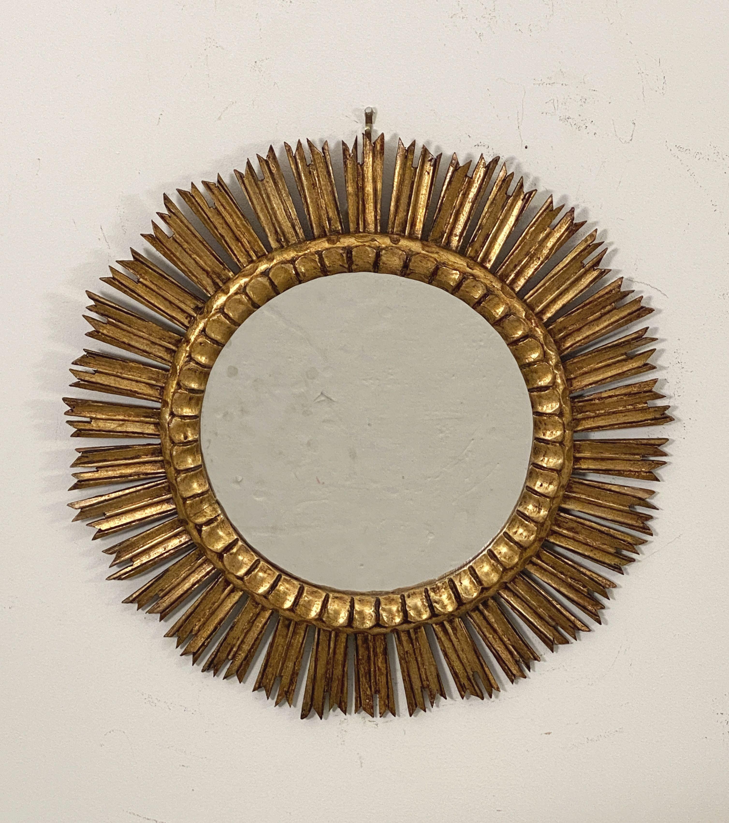 Un hermoso espejo dorado español con forma de sol (o de estrella), con una hilera de rayos de madera finamente dorados dispuestos alrededor de un centro de cristal de espejo.

Dimensiones: Diámetro de 25 pulgadas