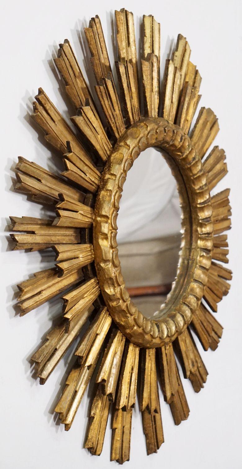 A beautiful Spanish gilt sunburst (or starburst) mirror with a double row of gilded wooden rays arranged around the mirror plate glass center.

Measures: Diameter of 25 1/2 inches