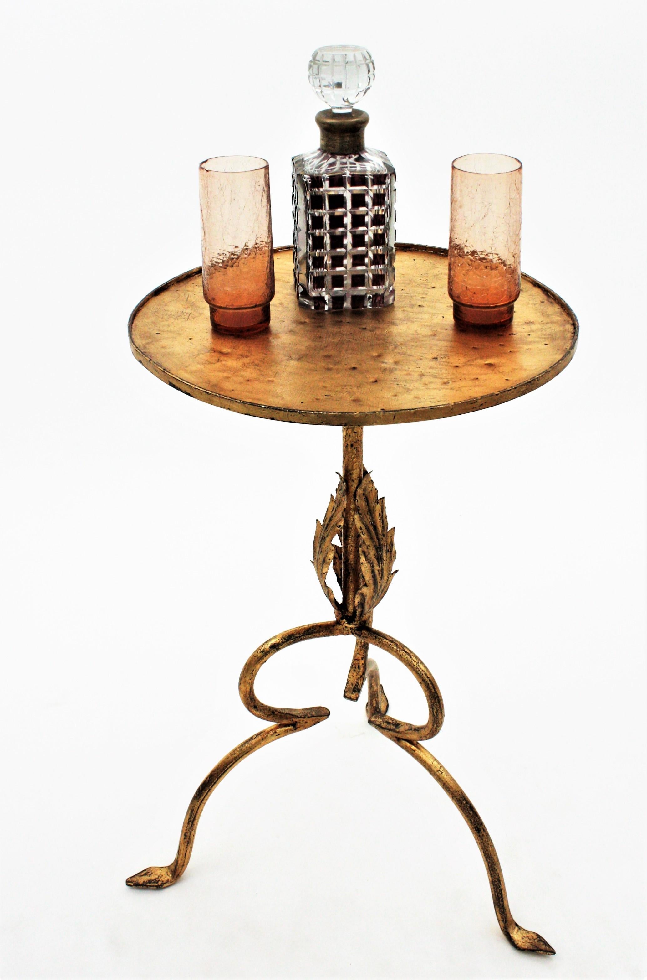 Spanish gold leaf gilt iron iron gueridon, end table or cocktails table with gilt iron leaves decorations. Spain, 1940s.
This Gothic style table was handcrafted in wrought iron and finished in gold leaf gilding. It has three leaves decorating the