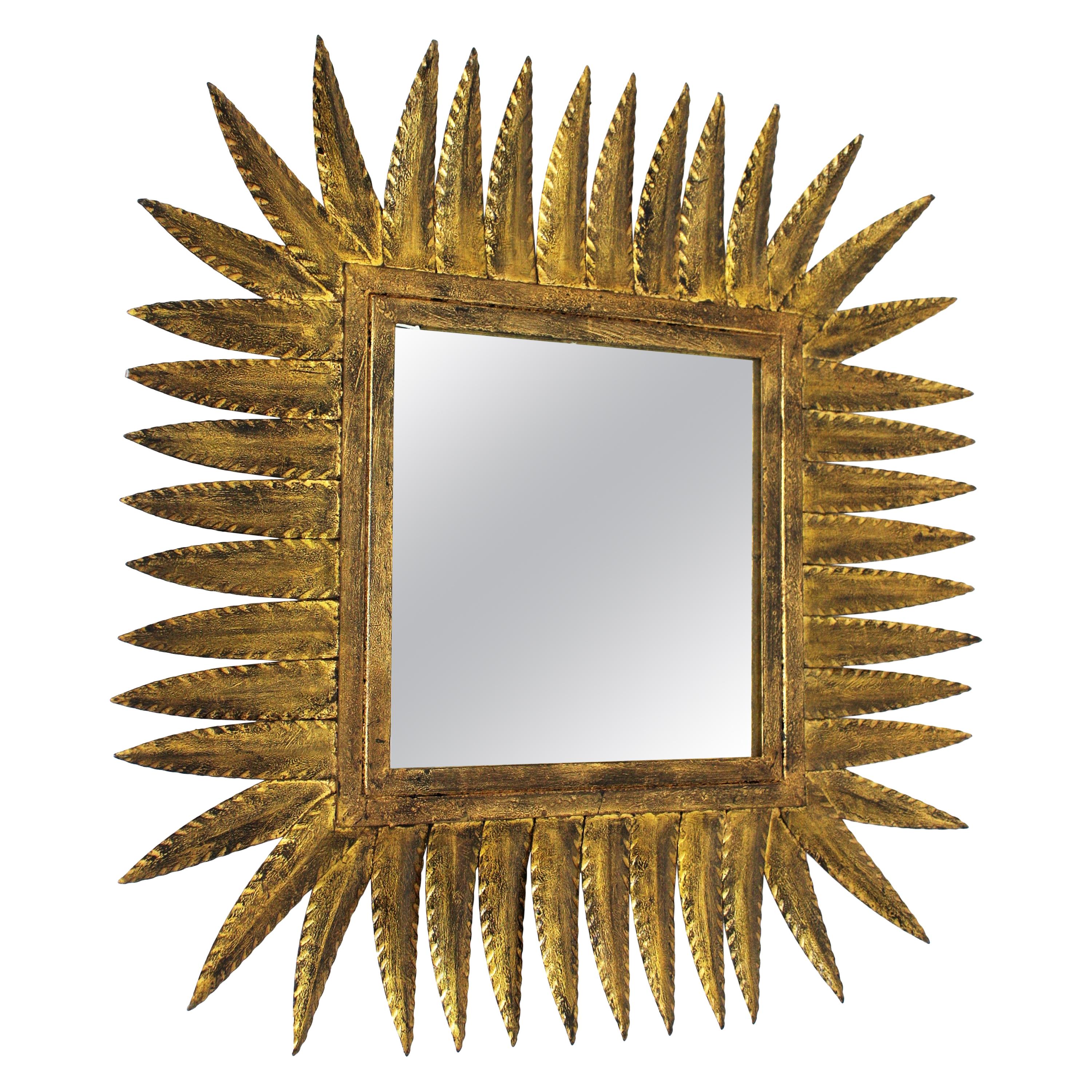 Hand-Hammered Gilt Iron Rhombus shaped sunburst mirror. Spain, 1950s. 
It can be placed in two positions. 
Manufactured by Ferro Art. 
This sunburst mirror will be a nice addition to a powder room or any other room. Place it alone or as a part of a