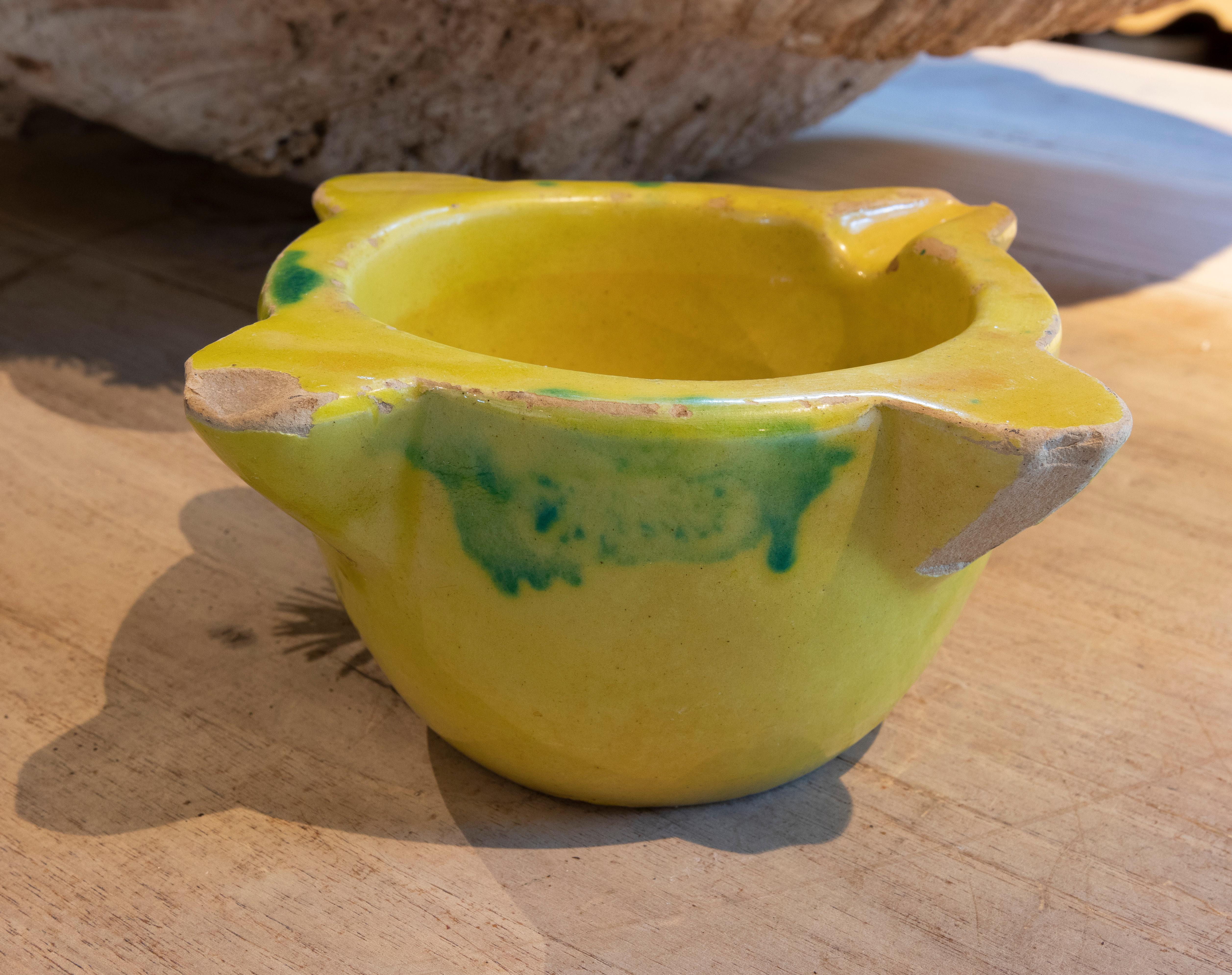 Spanish glazed ceramic mortar in yellow and green color.