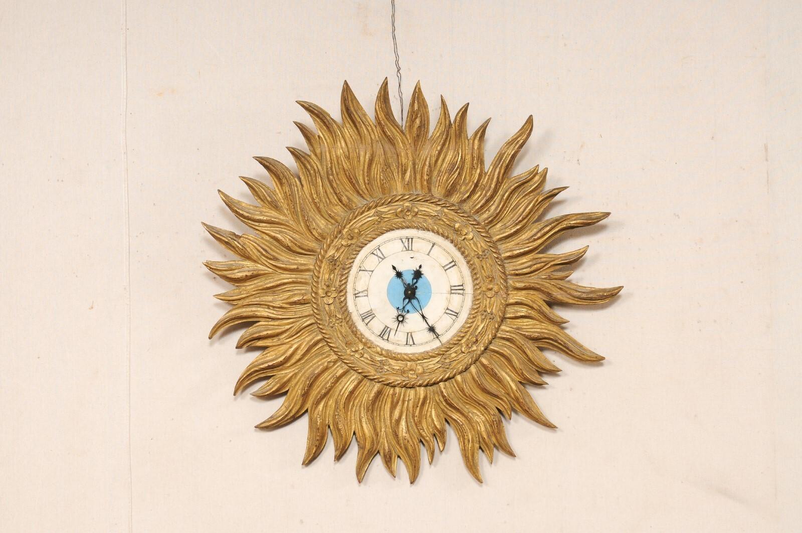 Eine spanische dekorative Wanduhr mit Sonnenschliff. Diese Vintage-Wanduhr aus Spanien, etwa 3 Fuß im Durchmesser, hat eine kreisförmige Uhr in der Mitte, mit einem inneren Seil und floralen geschnitzten Rahmen, und eine Reihe nach außen projiziert