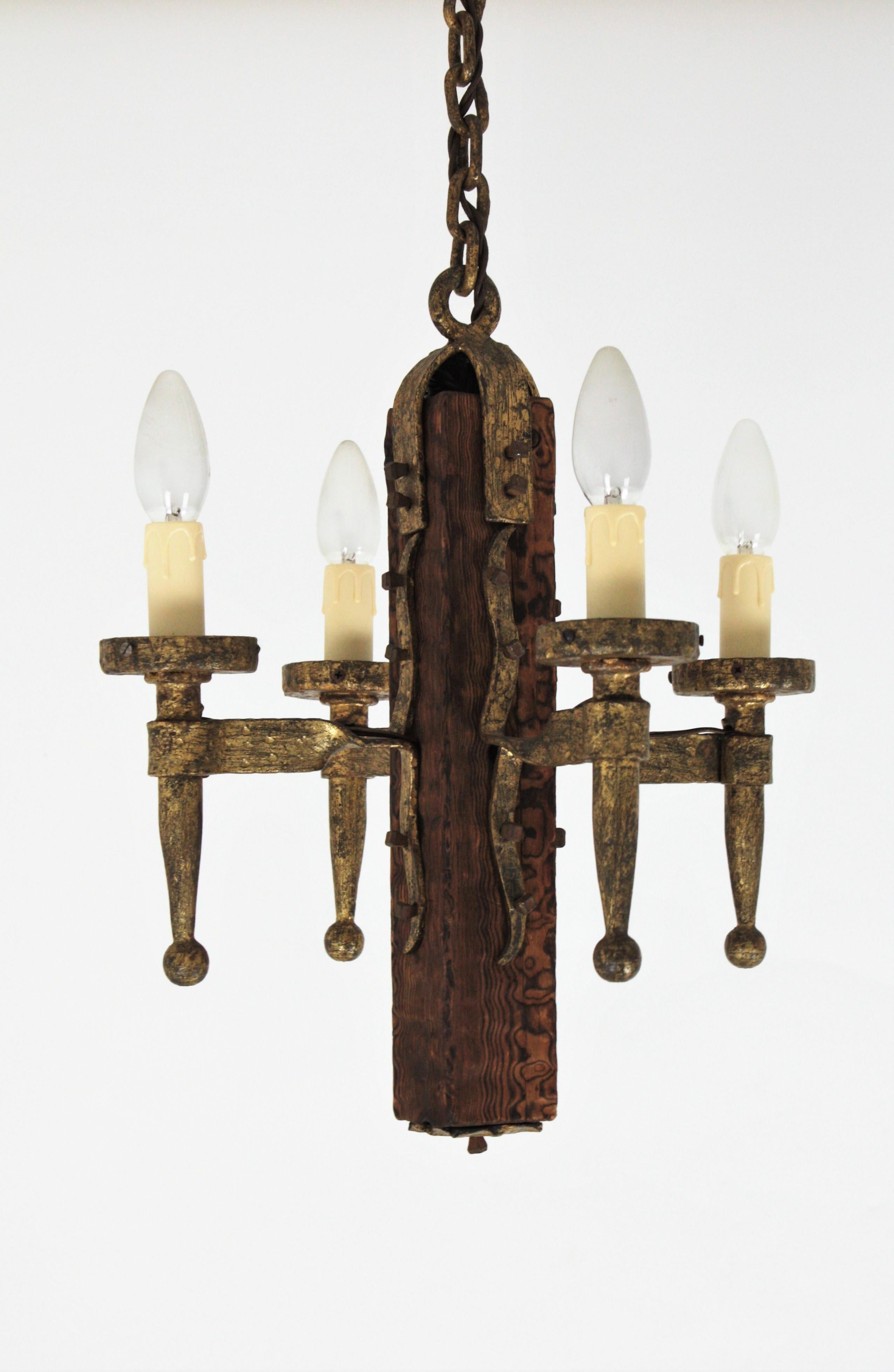 Hand forged iron and wood four-light torch pendant or ceiling hanging light, Spain, 1920s-1930s
This beautiful lamp features a rectangular wooden primitive base holding one wrought iron torch shaped arm on each side. The rectangle hangs from a