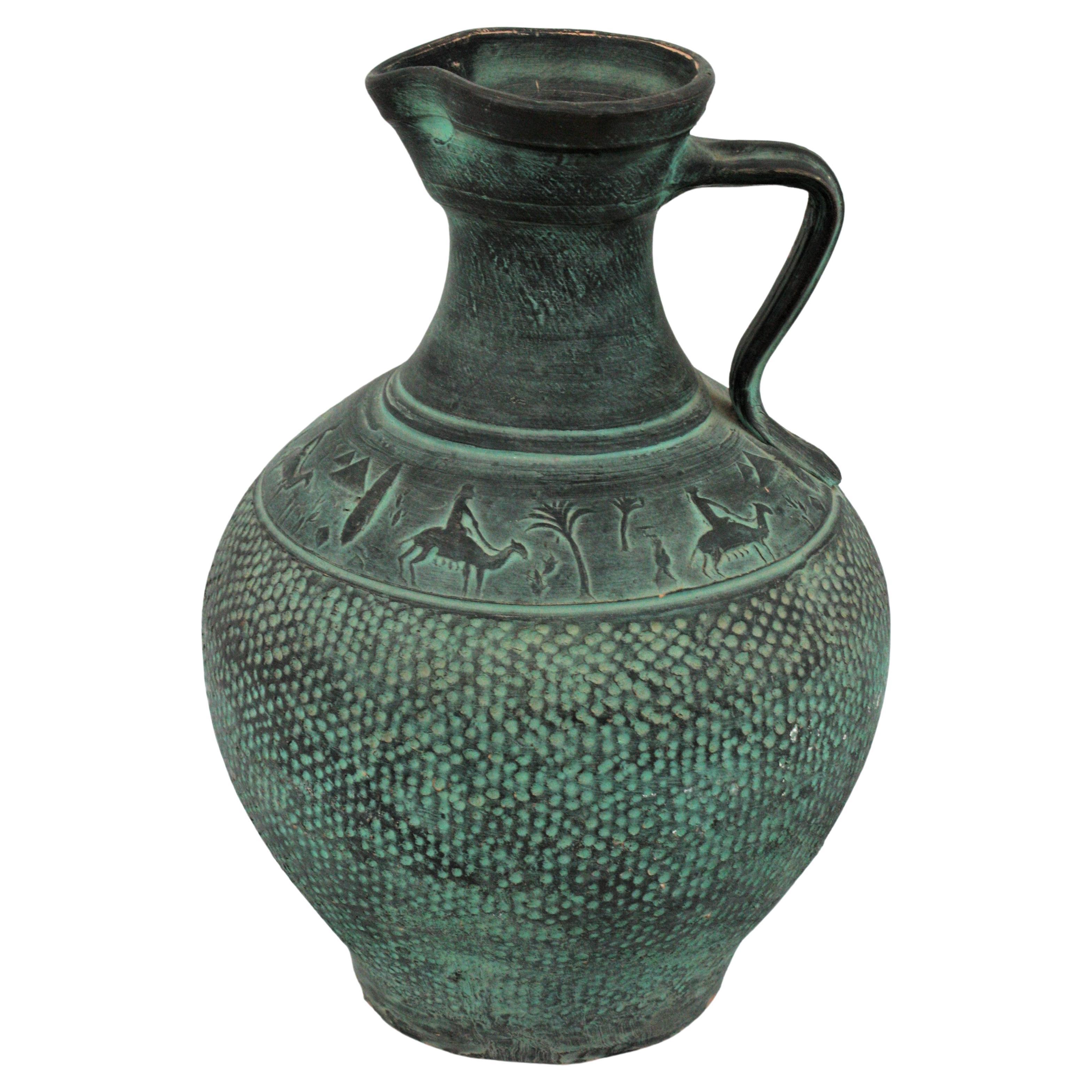 Large jug or vessel in green unglazed terracotta. Catalonia, Spain, 1950s
This outstanding jar vase has engraved dot details thorough the body and beautiful egyptian decor. Single handle at one side.
This mid-century jug has a design inspired in