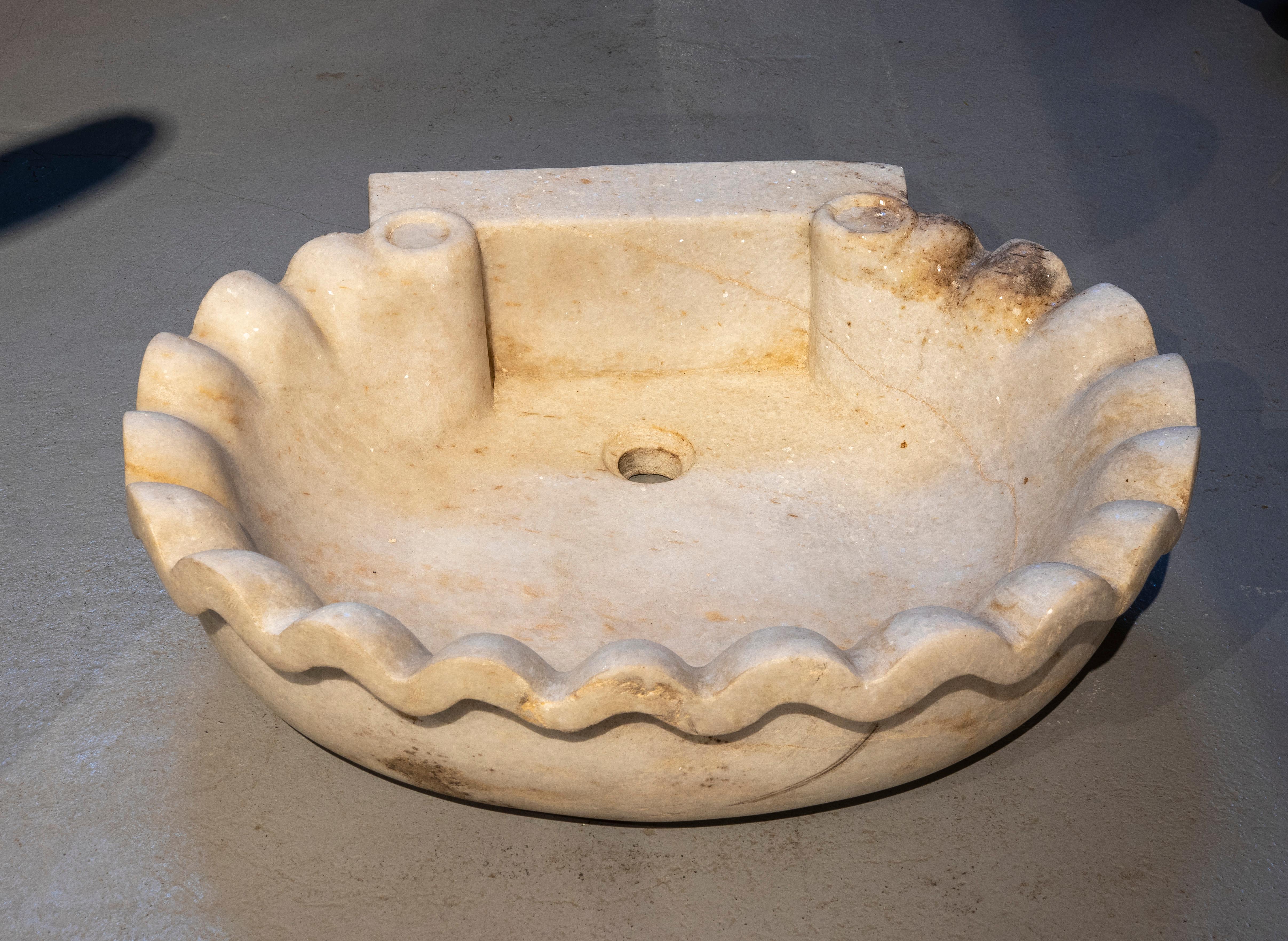 Spanish hand-carved marble washbasin with shell shape.