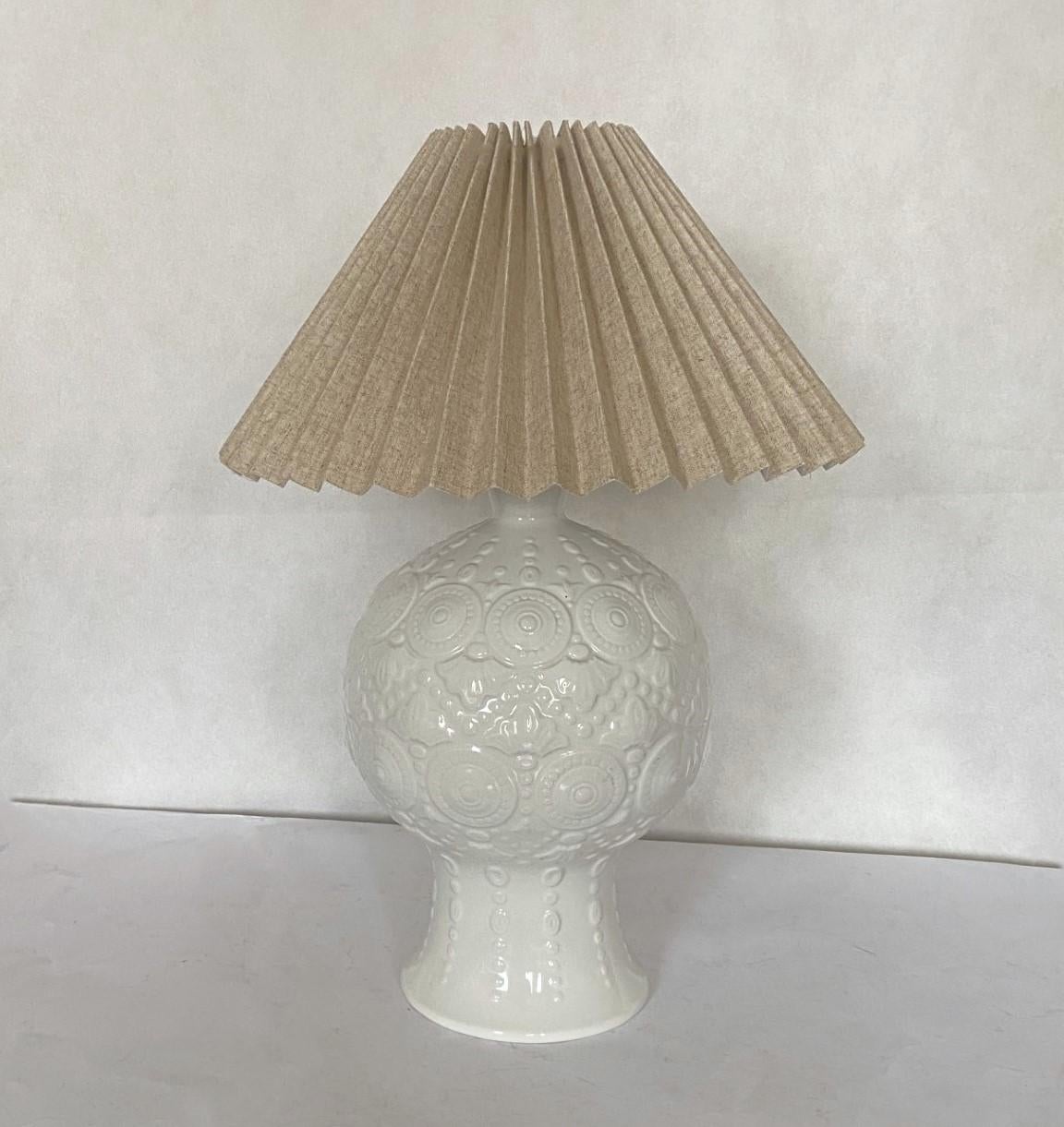 A wundelful hand-crafted white ceramic vase table lamp, textured high-relief and glazed, with a linen plissee  shade,marked on the base, Spain, 1970s. In very good vintage condition, no damages, with new conical off-white shade. Switch to turn on
