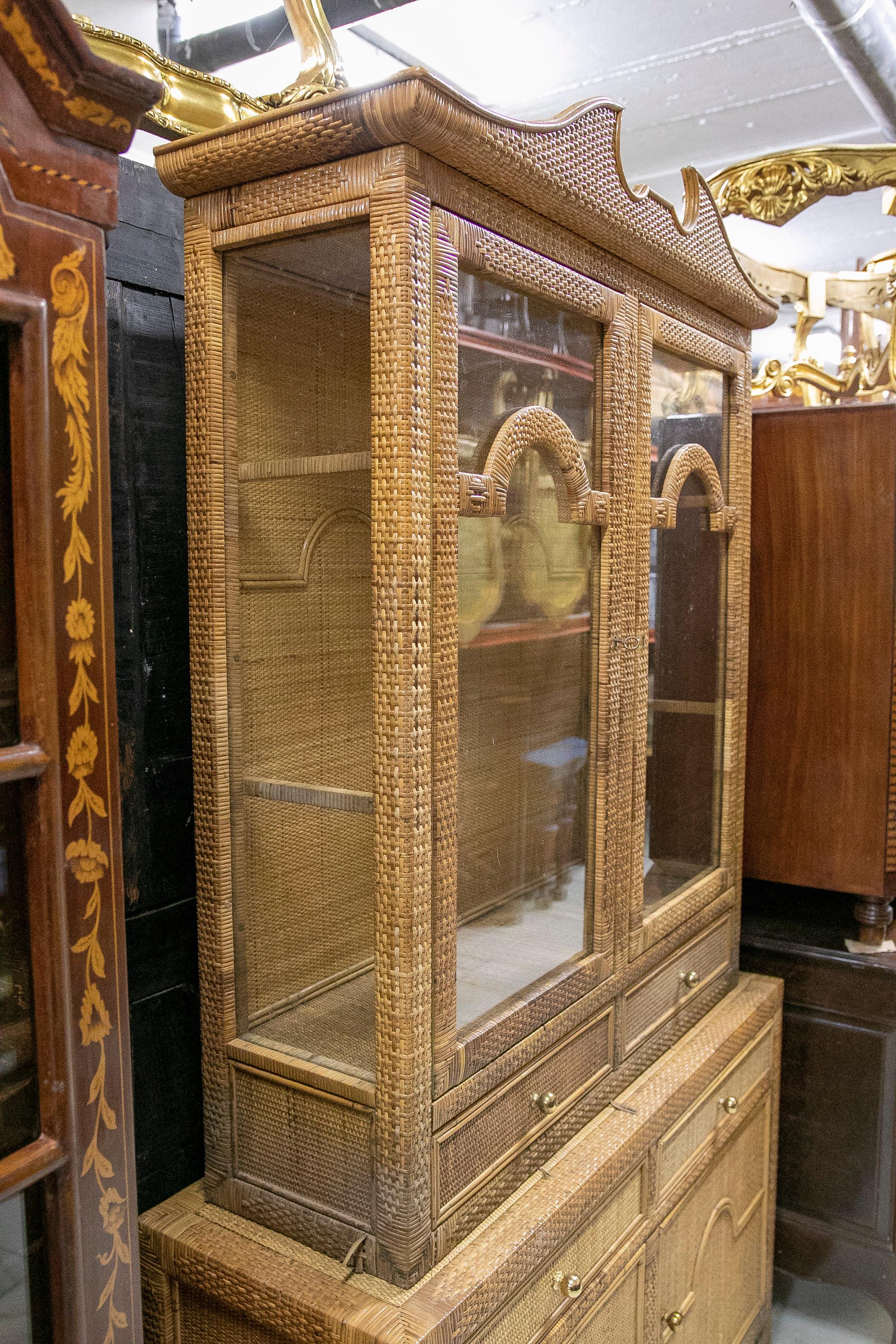 Spanish handmade wicker display cabinet with drawers and doors. Glass in the upper part with shelves inside, wooden frame and decorated with hand sewn wicker from the 1970s.