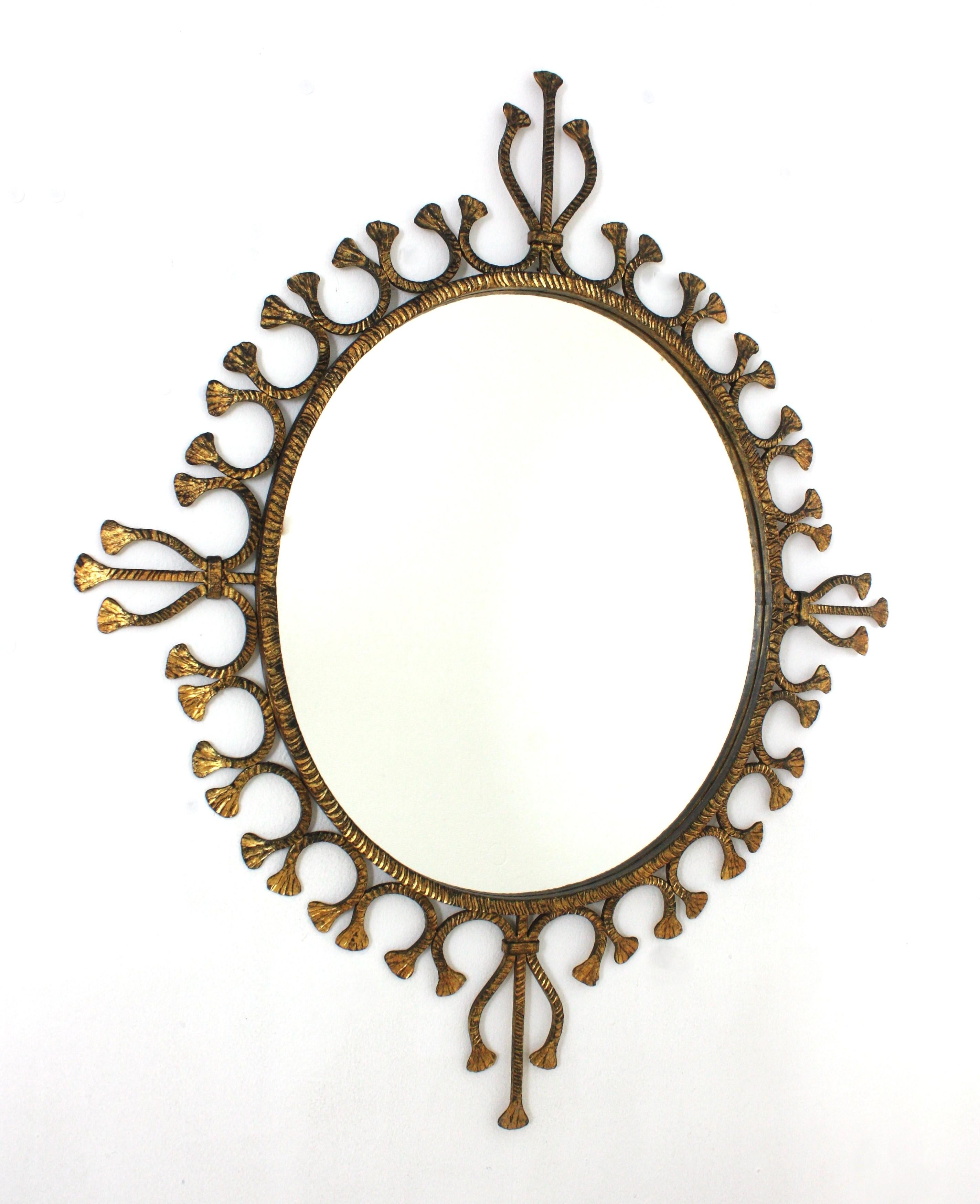 One of a kind Tassel Motif Sunburst Wall Mirror, Hand Forged Iron, Gold Leaf Spain, 1940s
Eye-catching Hollywood Regency gold gilt wrought iron sunburst mirror with tassel motifs on the frame.
This hand forged iron mirror was manufactured in Spain.