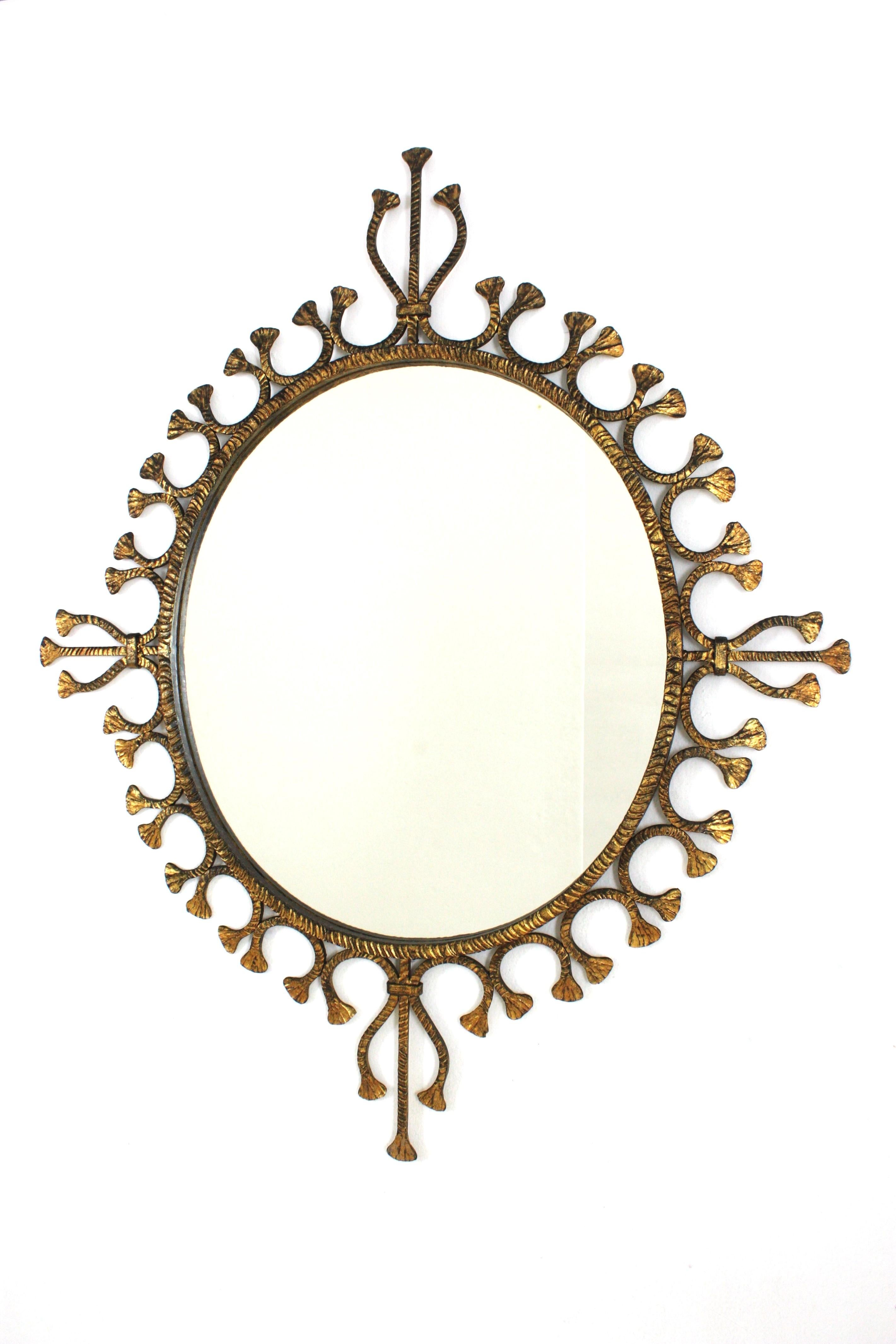 Foglia d’oro Specchio ovale a raggiera in ferro battuto dorato Hollywood Regency spagnolo / Specchio da parete in vendita