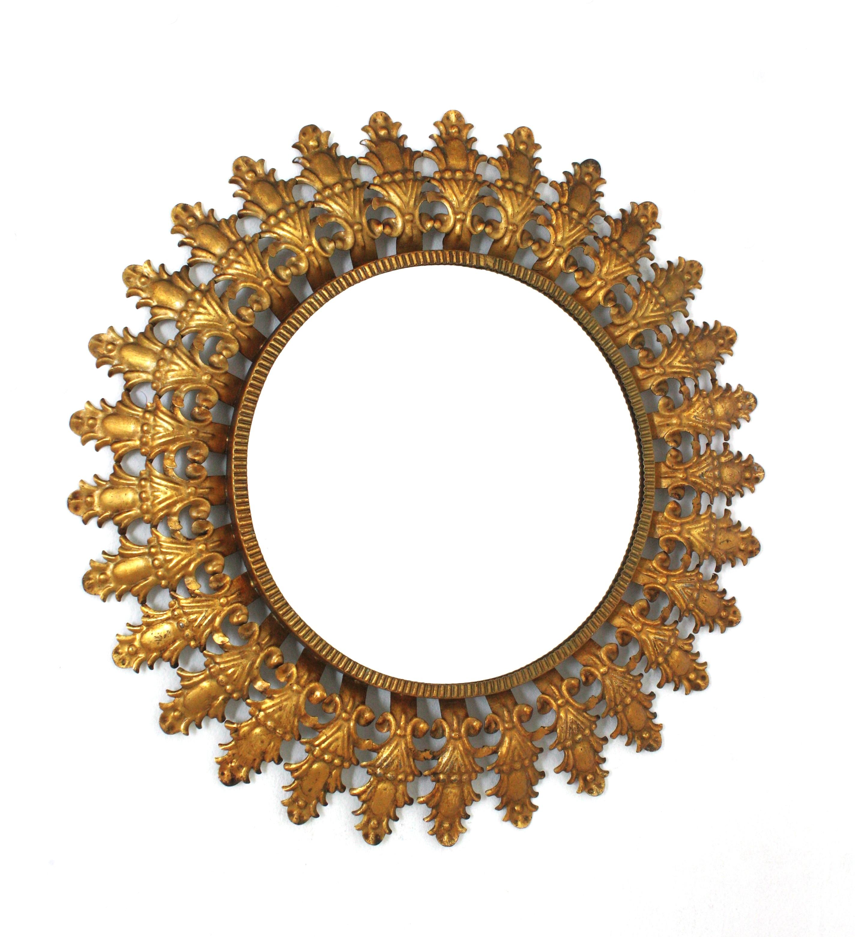 Specchio a raggiera con fogliame dorato / Specchio da parete rotondo
Specchio ovale a raggiera in ferro della Modernità di metà secolo con cornice a foglia e finitura a foglia d'oro, Spagna, anni '50.
Questo accattivante specchio a raggiera ha un