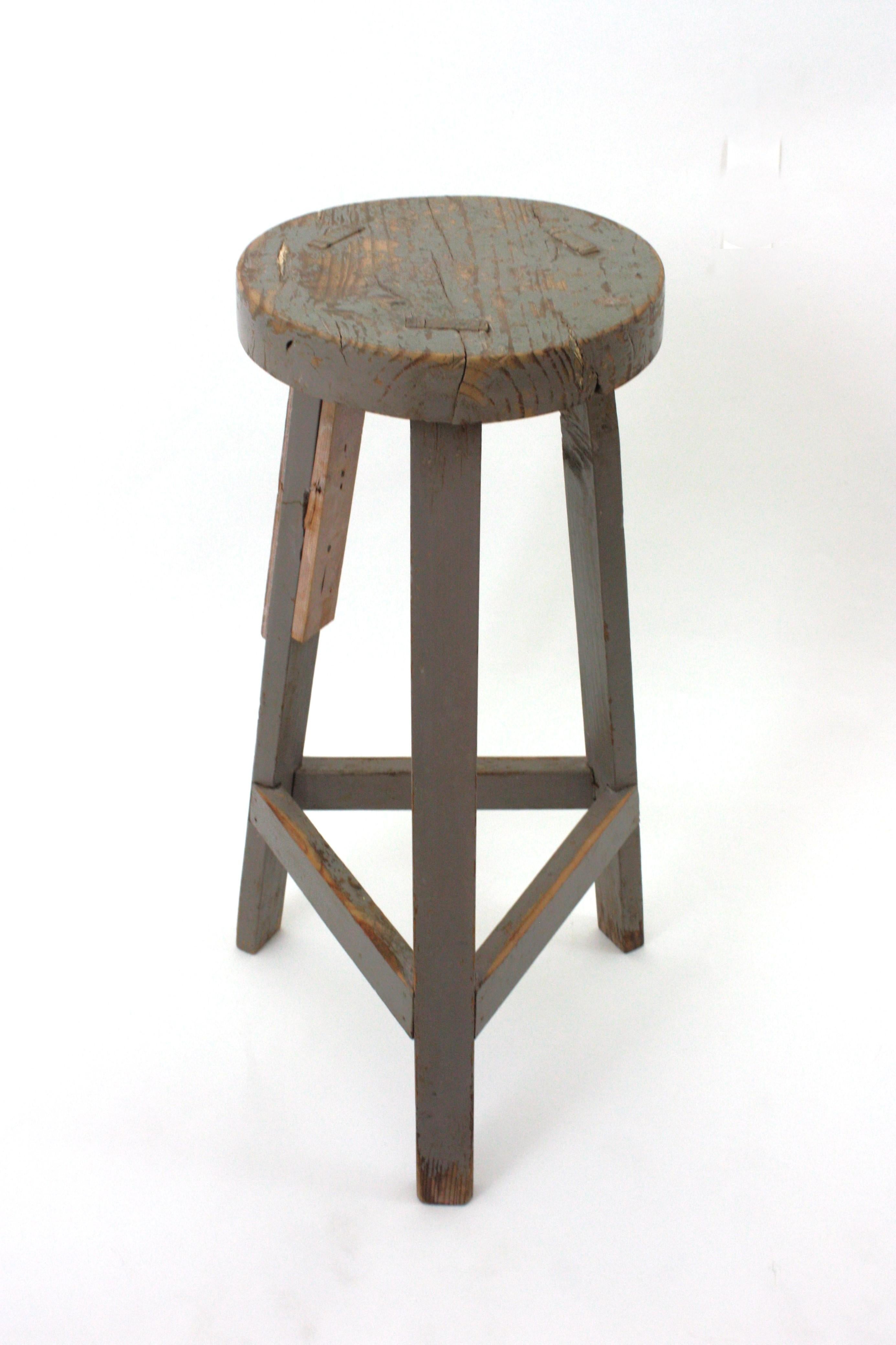 Taburete alto del Taller de Escultura, España 193s0s-1940s.
Taburete industrial de madera con base de tres patas en pátina gris. 
Este taburete alto de taller tiene una construcción pesada, gran forma y carácter. Tiene tres patas con estrías de