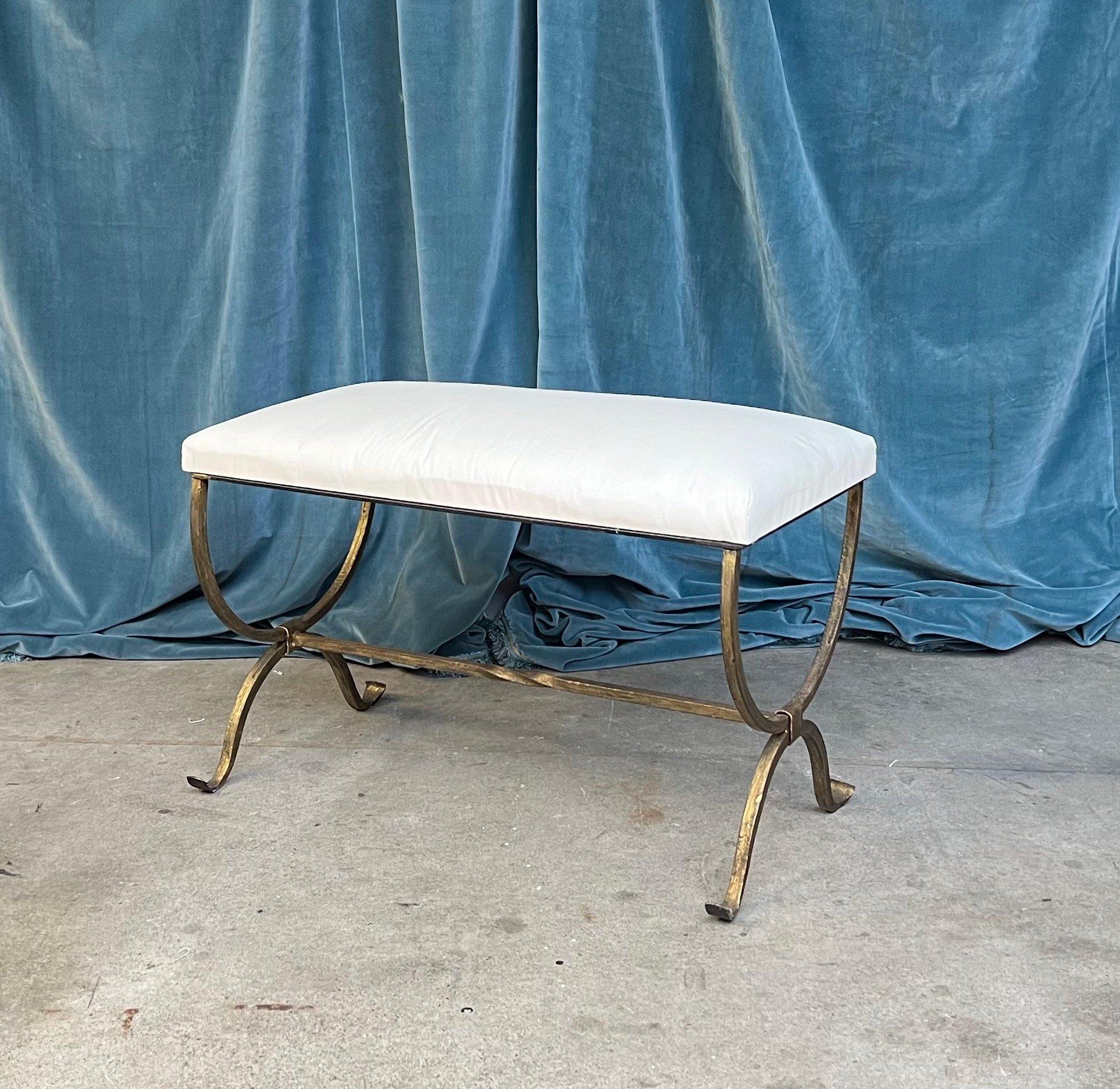 This elegant Spanish gilt iron bench was recently made by skilled artisans and features gently scrolled legs and a stretcher with a decorative center twist. Handmade by expert European craftsmen, it has a hand forged iron base with a rich but subtle