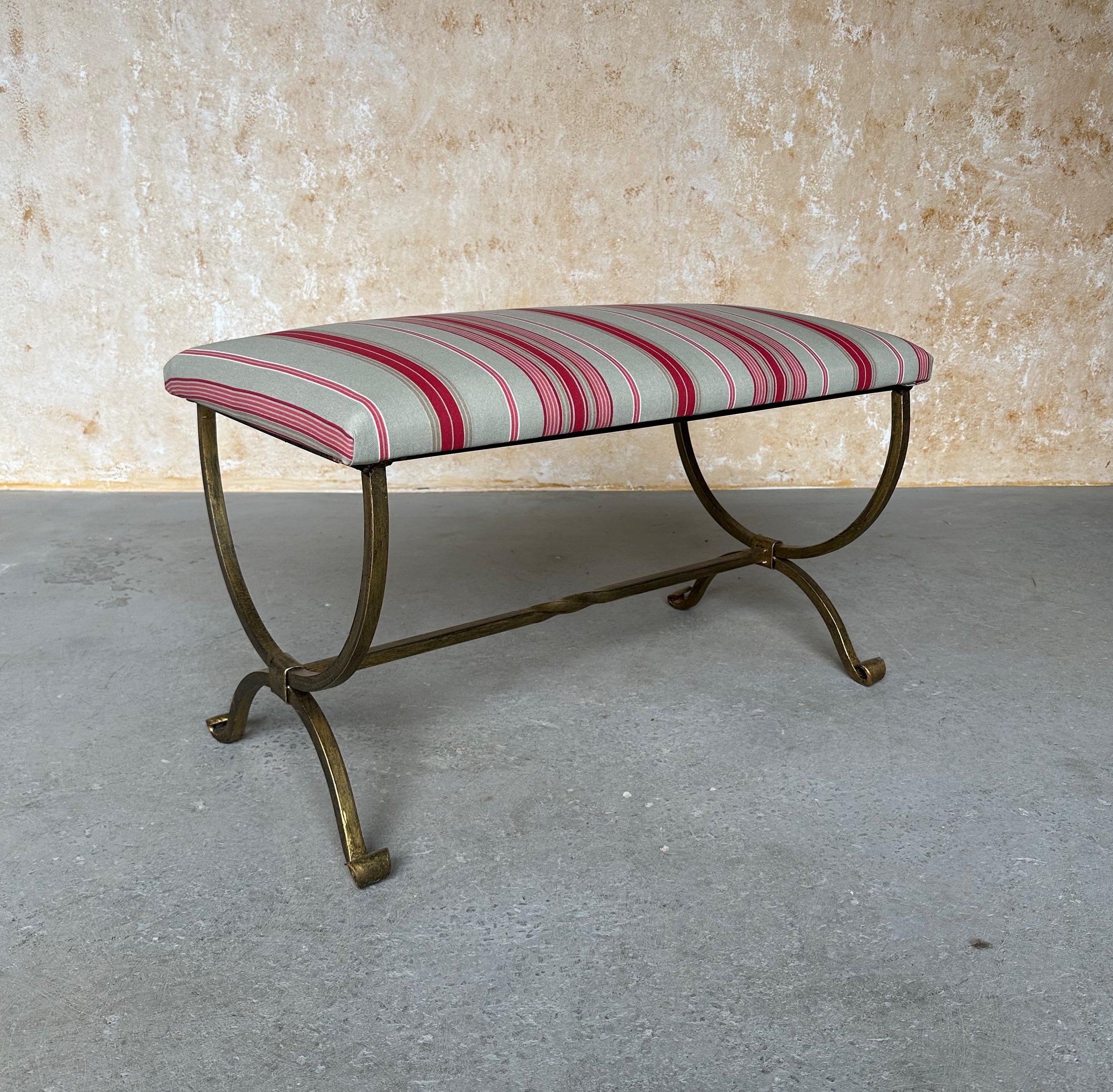 Questa bellissima panca spagnola in ferro dorato è stata realizzata di recente da abili artigiani europei e presenta gambe graziosamente arcuate e una barella con una torsione centrale decorativa. Realizzato a mano da esperti artigiani, ha una base