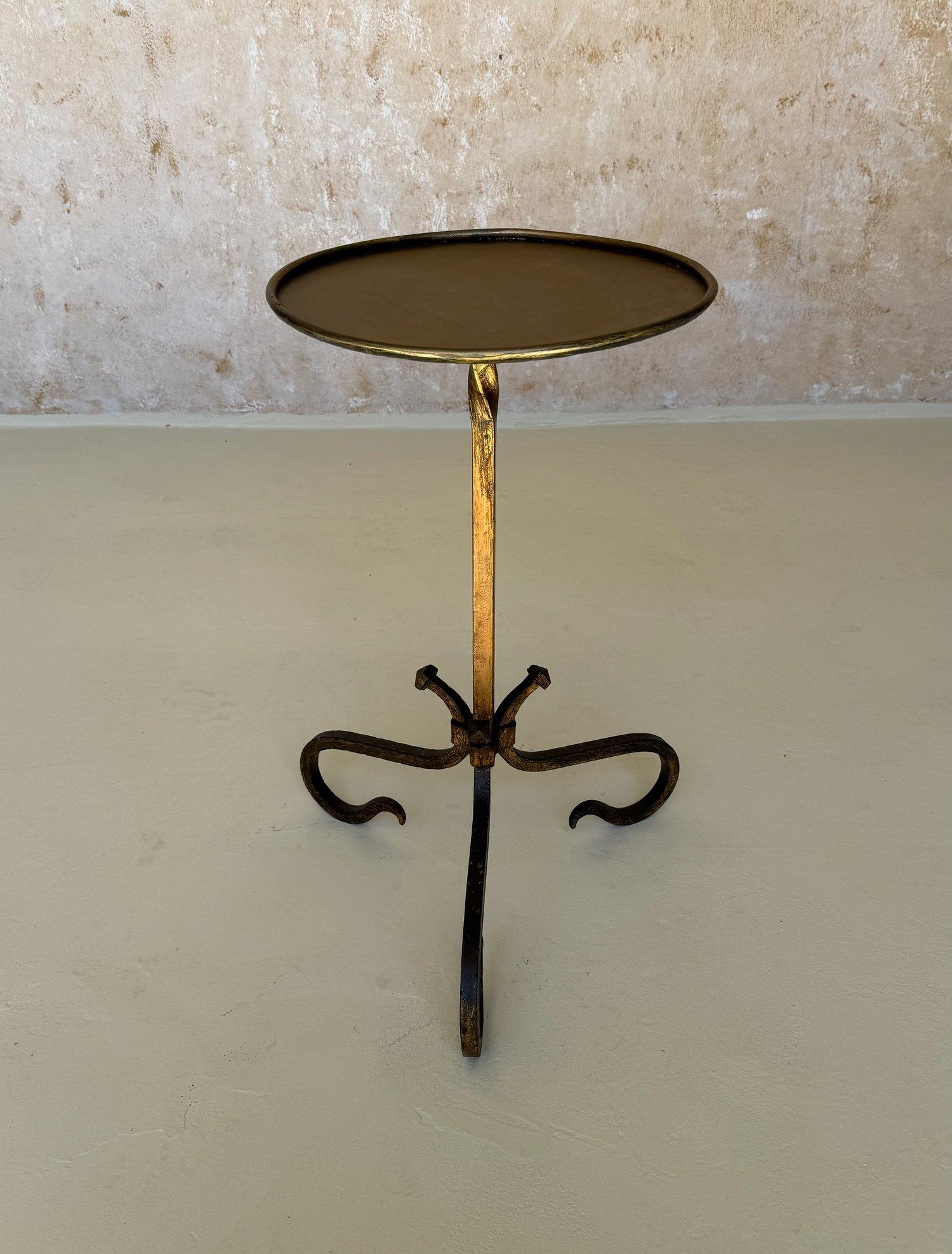 This charming Spanish drinks table was recently handcrafted by skilled European artisans employing traditional iron-working techniques. Hand forged from iron, it features a central stem with a decorative twist detail mounted on an ornate tripod base