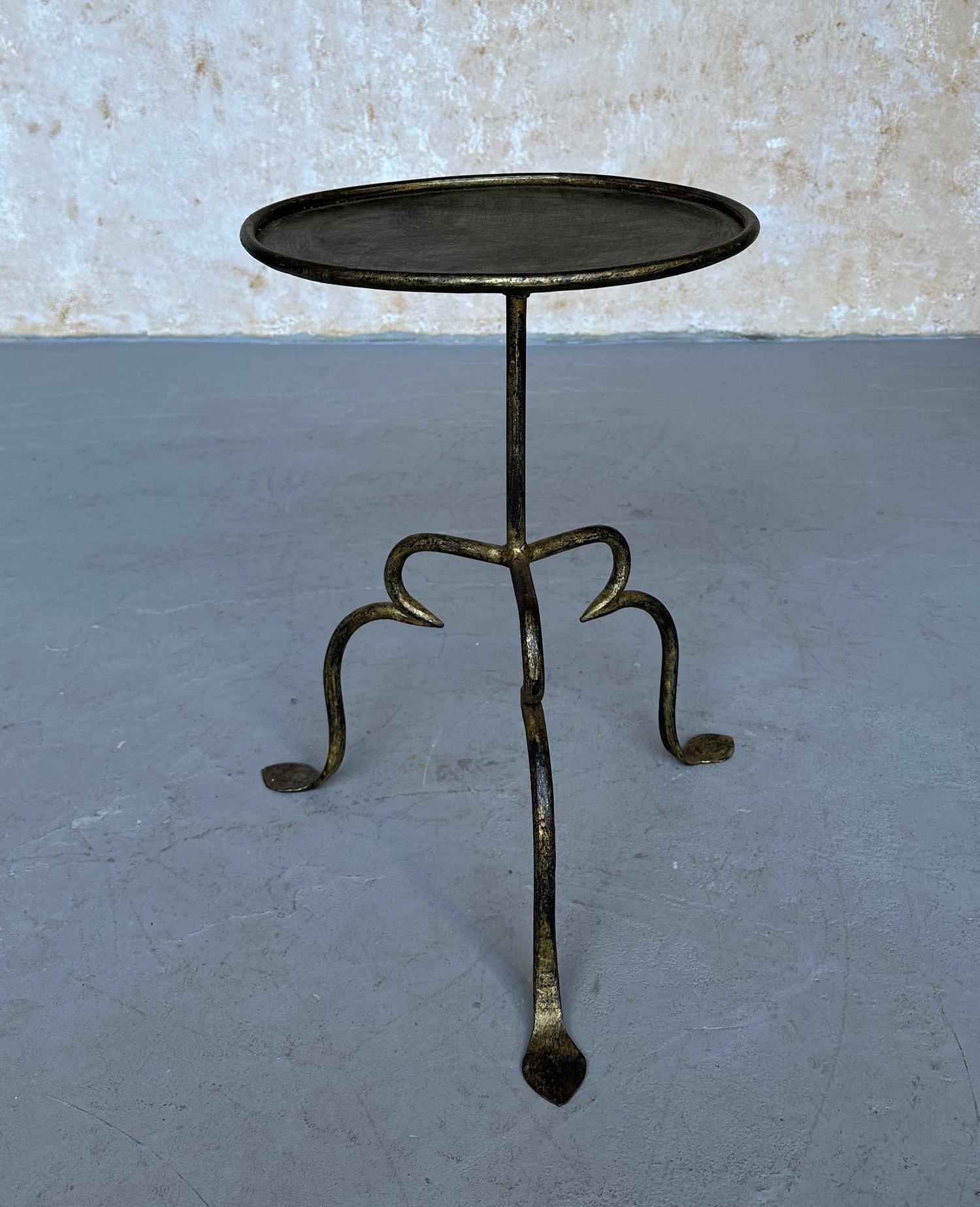 This charming drinks table was recently hand-crafted by skilled European artisans using traditional iron working techniques. It features a central stem with a decorative ring detail mounted on an elevated tripod base with elegantly curved legs