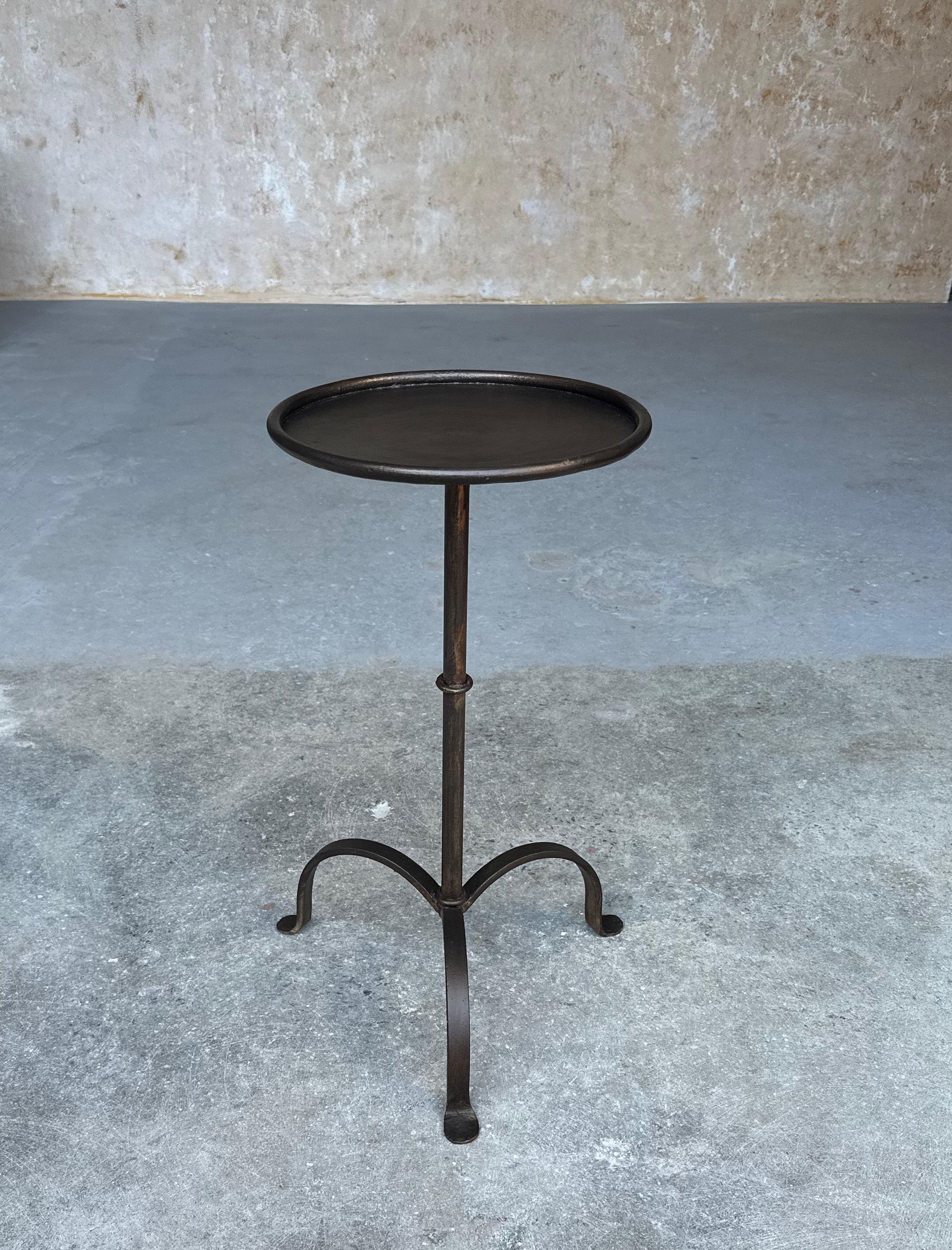 Dieser kürzlich handgefertigte kleine spanische Eisentisch ist nicht nur elegant, sondern auch funktionell. Der kreisförmige Stiel, der einem Vintage-Design aus den 1950er Jahren nachempfunden ist, wird von einem zentralen Ring akzentuiert, der als