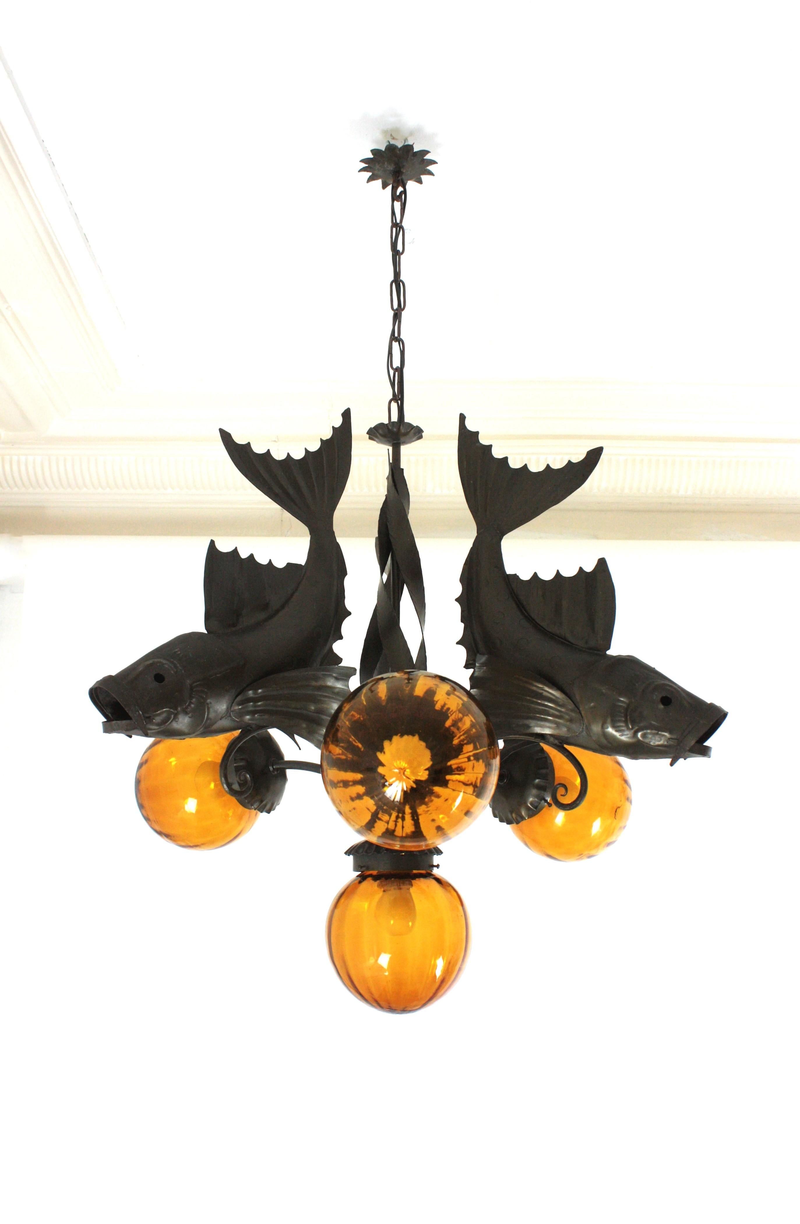 Large Wrought Iron Fishes Chandelier with Blown Glass Globe Shades. Spain, 1950s-1960s
Rare find.
This four-light ceiling lamp was handcrafted in Spain at the Mid-Century Modern period in the style of Brutalism. 
It features 3 large iron fishes