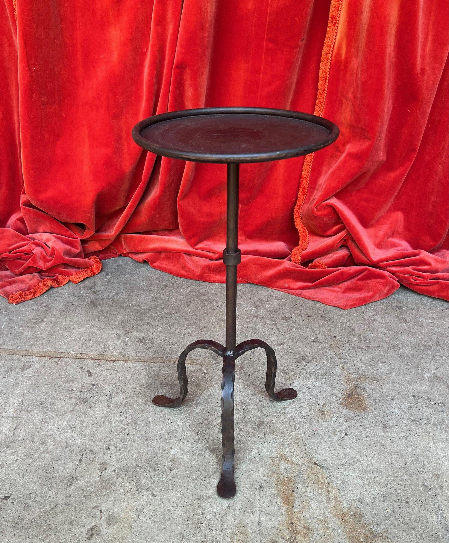 An elegant Spanish small-scale iron and metal drinks table from the 1950s, having a perfect blend of elegance and vintage appeal. Crafted with a circular central stem adorned by a decorative collar accent, this captivating table stands on a tripod