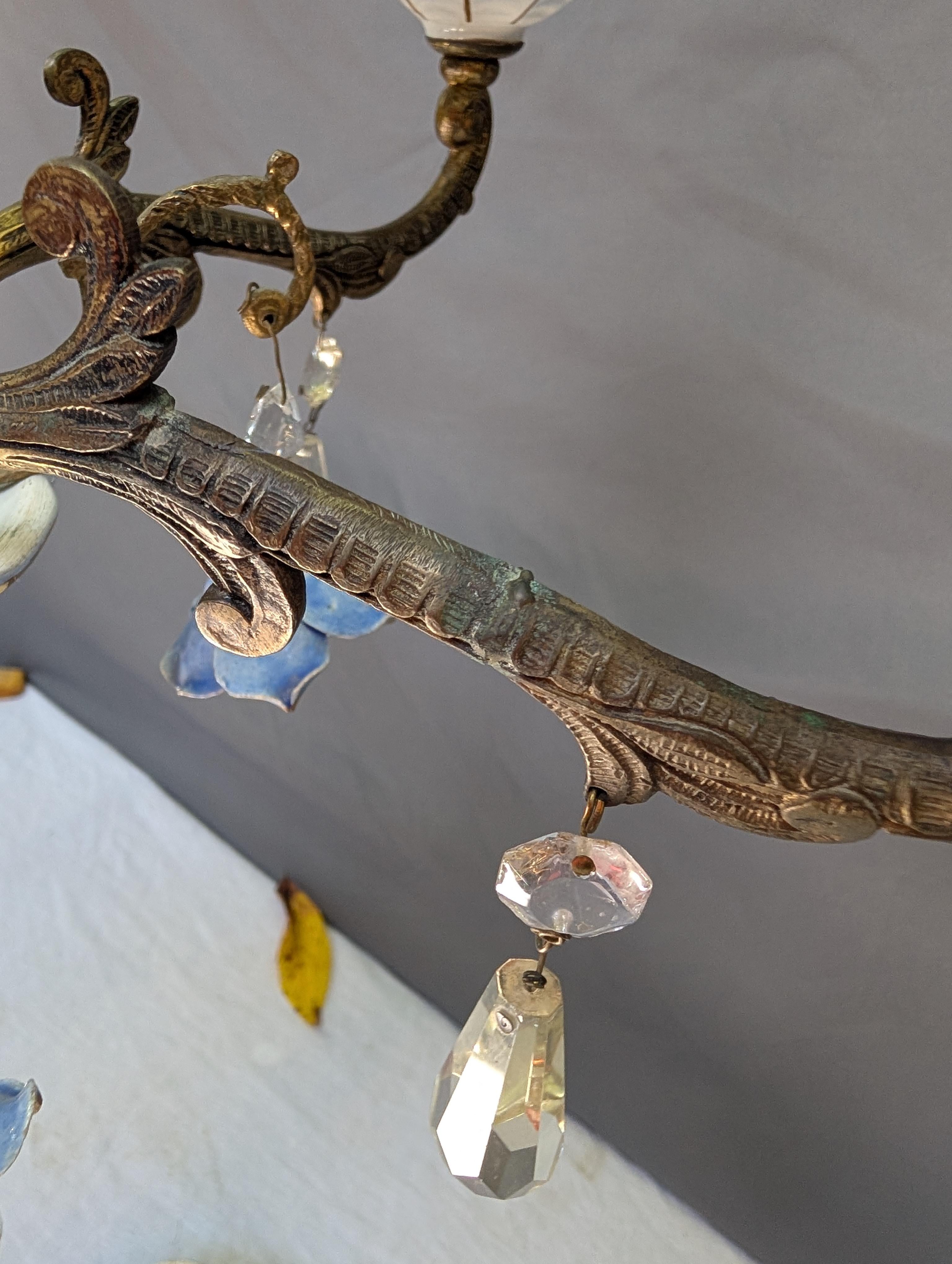 Spanish-Italian Porcelain Chandelier
Beautiful, Good Condition
Porcelain and Brass with Porcelain Flowers and Crystal Prism
Includes matching cover for electric plate in the ceiling (see pic)
Unsure of manufacture or country
Possibly one brass arm