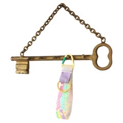 Colgador de pared con forma de llave española en hierro forjado dorado, años 40