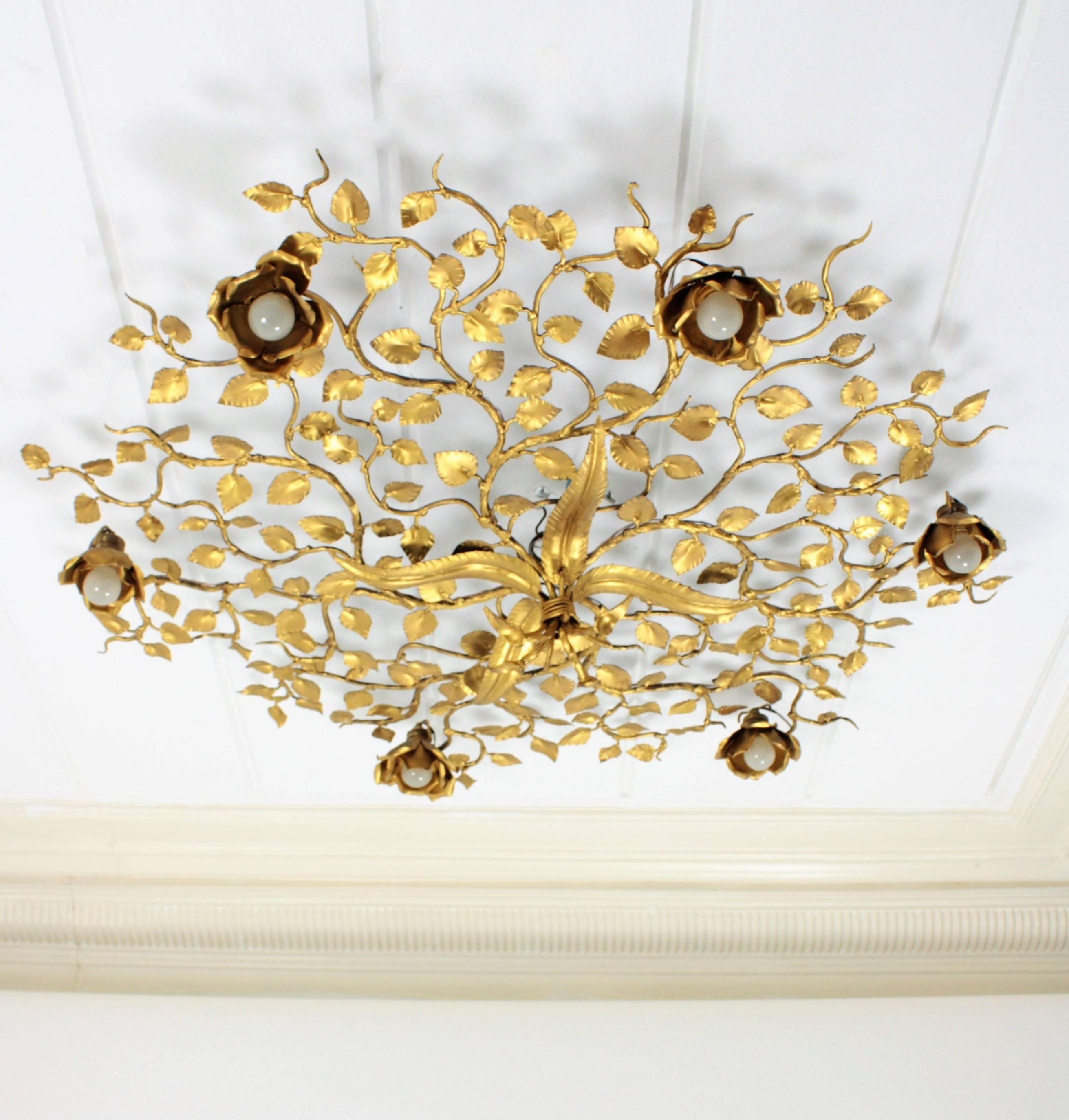 Unusual large size hand hammered gilt iron ornate flower bush ceiling light fixture with six flower lights. An spectacular Hollywood Regency style piece to preside a main room or a living room. This light fixture could also work as a big wall sconce