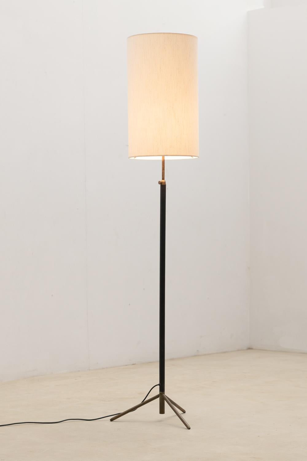 Elegant floor lamp featuring a sleek black leather-covered stem complemented by a brass tripod base.

New shade.

Do not hesitate to contact us for any additional information. We would be more than delighted to assist you in any way we can.

