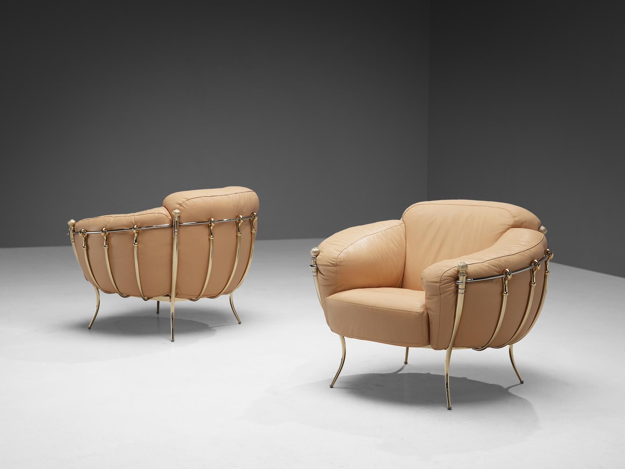 Lounge chairs, leather, brass, Spain, 1980s

A highly delicate pair of club chairs with voluminous shapes and eccentric decorations. The brass frame is composed of curved tubes that are beautifully bent at the ends. Four outer legs resemble pillars