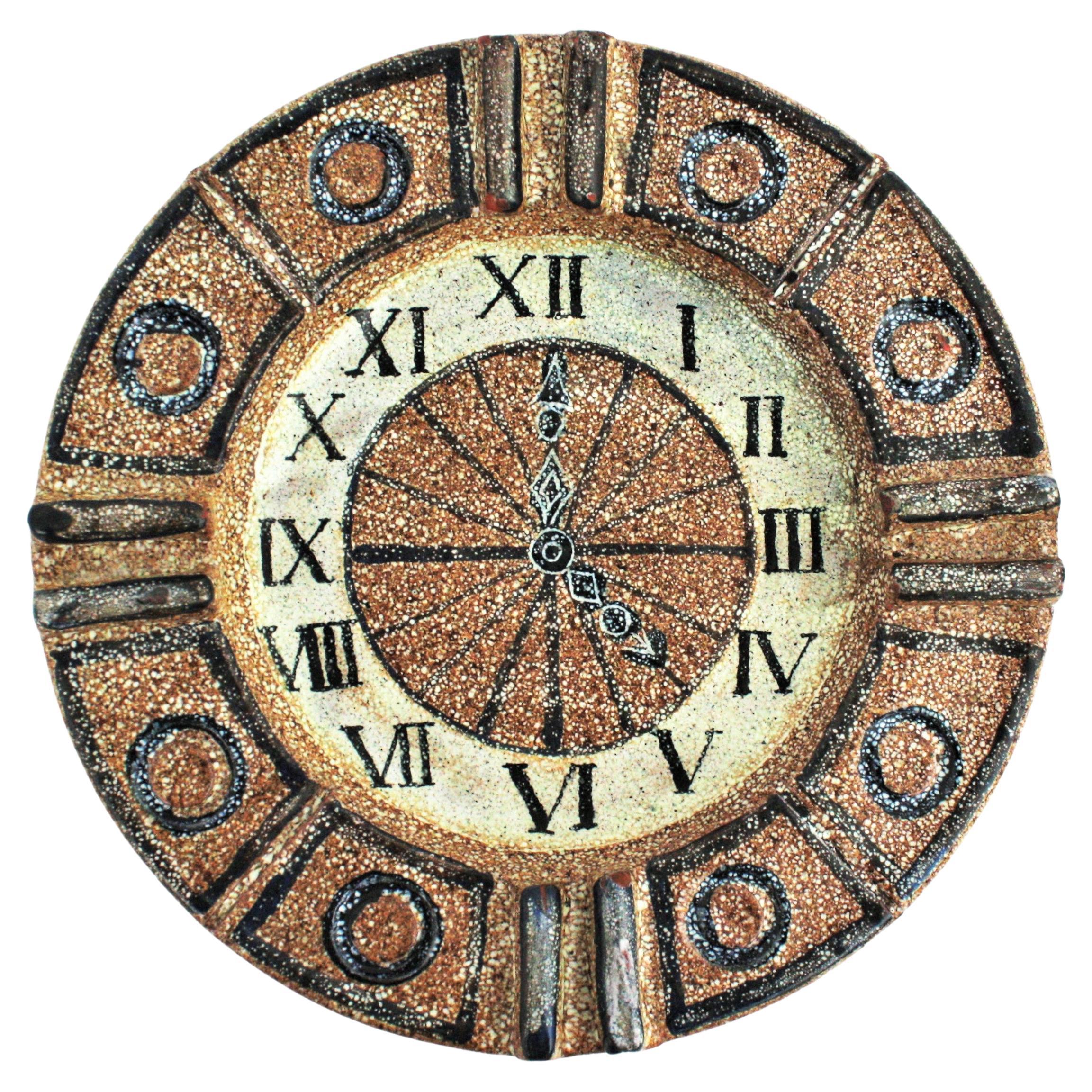Auffälliger runder Aschenbecher aus glasierter Terrakotta-Keramik mit handgemaltem Uhrendesign, Spanien, 1960er Jahre.
Hergestellt von Alfaraz Werkstatt/Atelier in Madrid.
Lehm mit einer glasierten Keramikoberfläche in Bernstein, Beige und