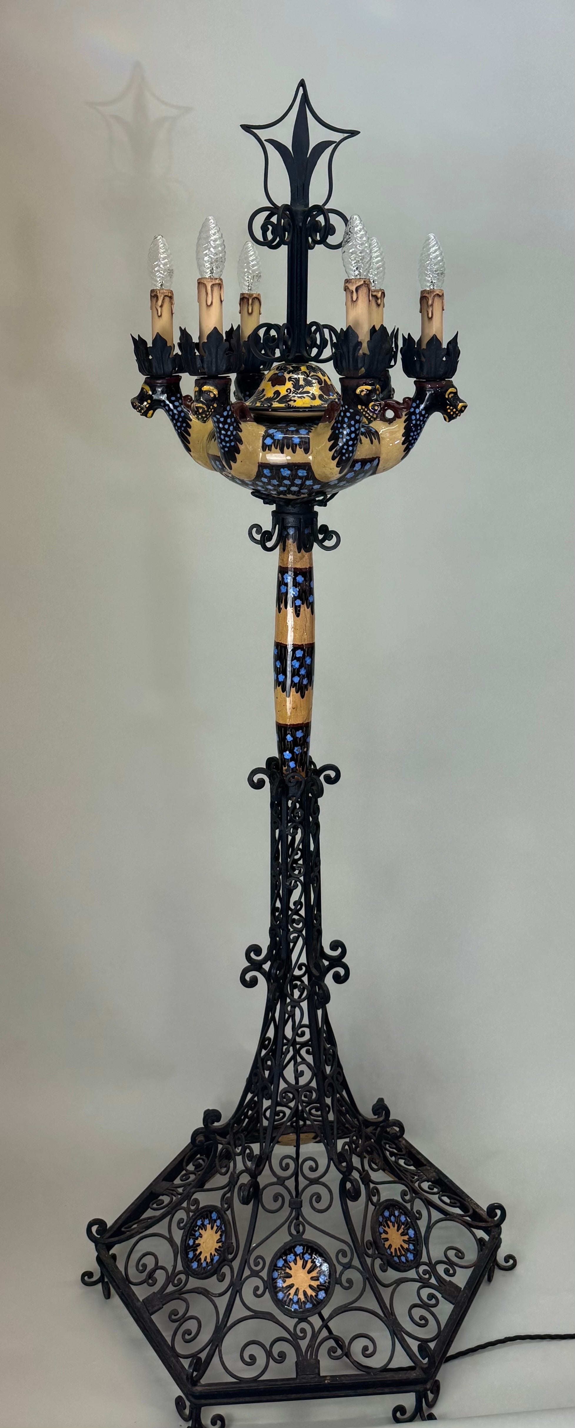 Excepcional lámpara de pie de Manises, España, hacia 1900, que une la cerámica mayólica ricamente vidriada con un elaborado trabajo de hierro forjado de estilo renacimiento gótico.

La base y la estructura de hierro forjado presentan intrincadas