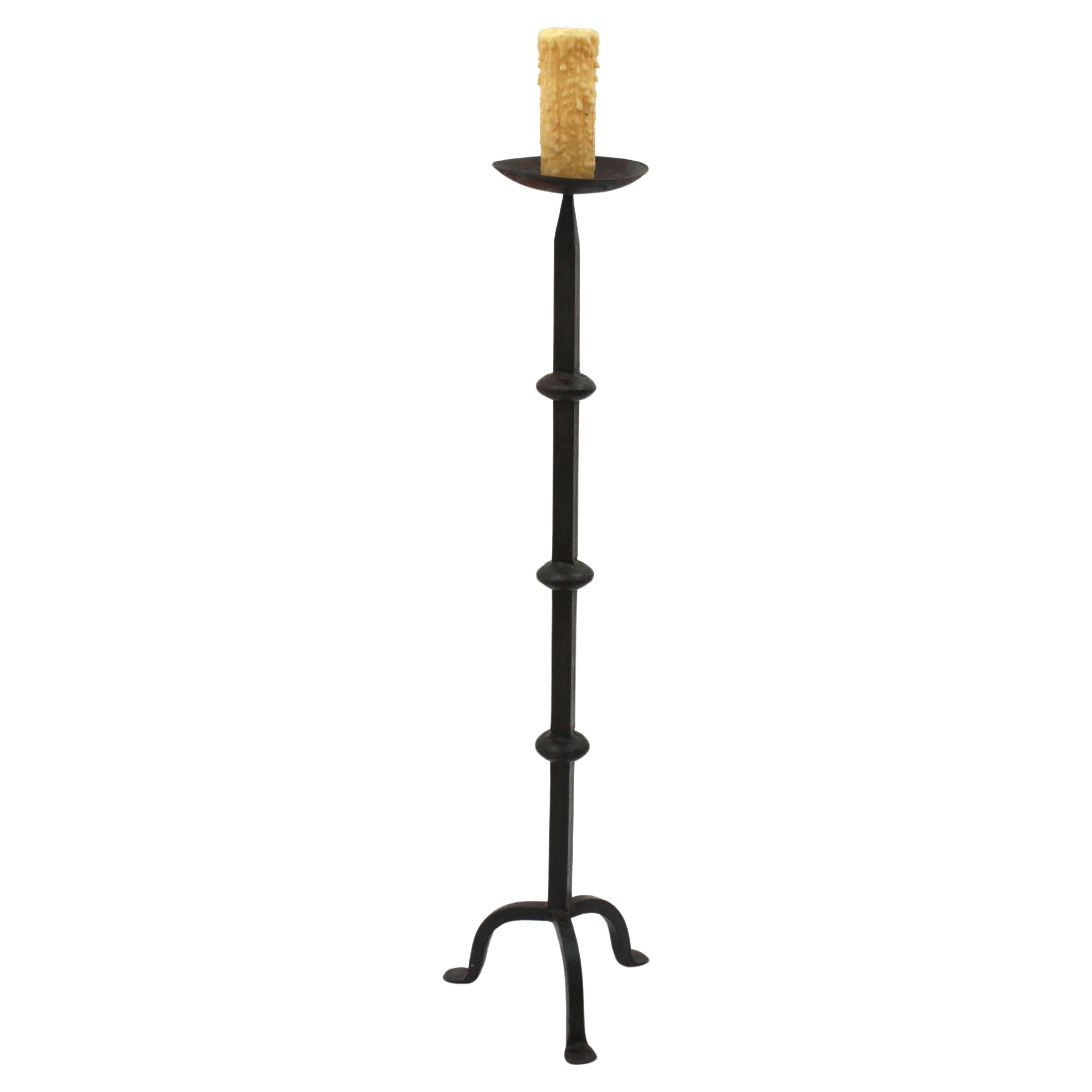 Gorgeous handwrought torchère candle holder, Spain, 1940s
This medieval style floor candleholder stands up on three legs tripod base. It has a terrific aged patina. It has a clean design inspired in Gothic style, with ring decorations at the central