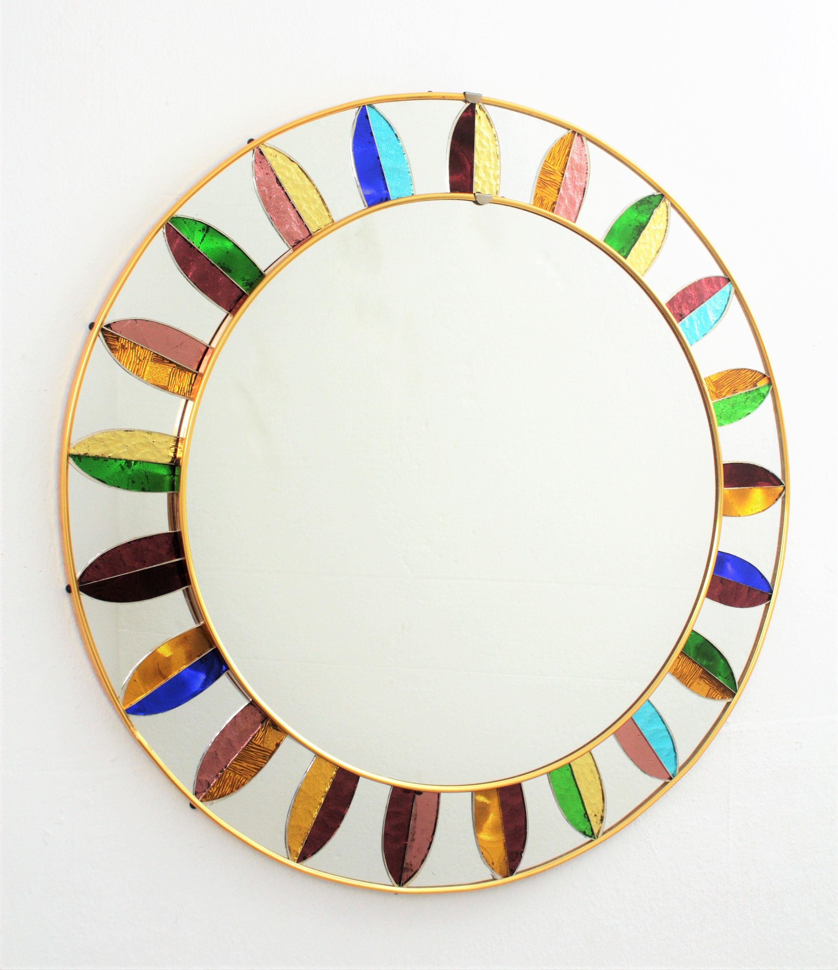 A highly decorative Mid-Century Modern circular mirror framed by leaves composed by pieces of mirrored glasses in different colors creating a sunburst pattern. Spain, circa 1960s. Central glass diameter: 42.5 cm.

 