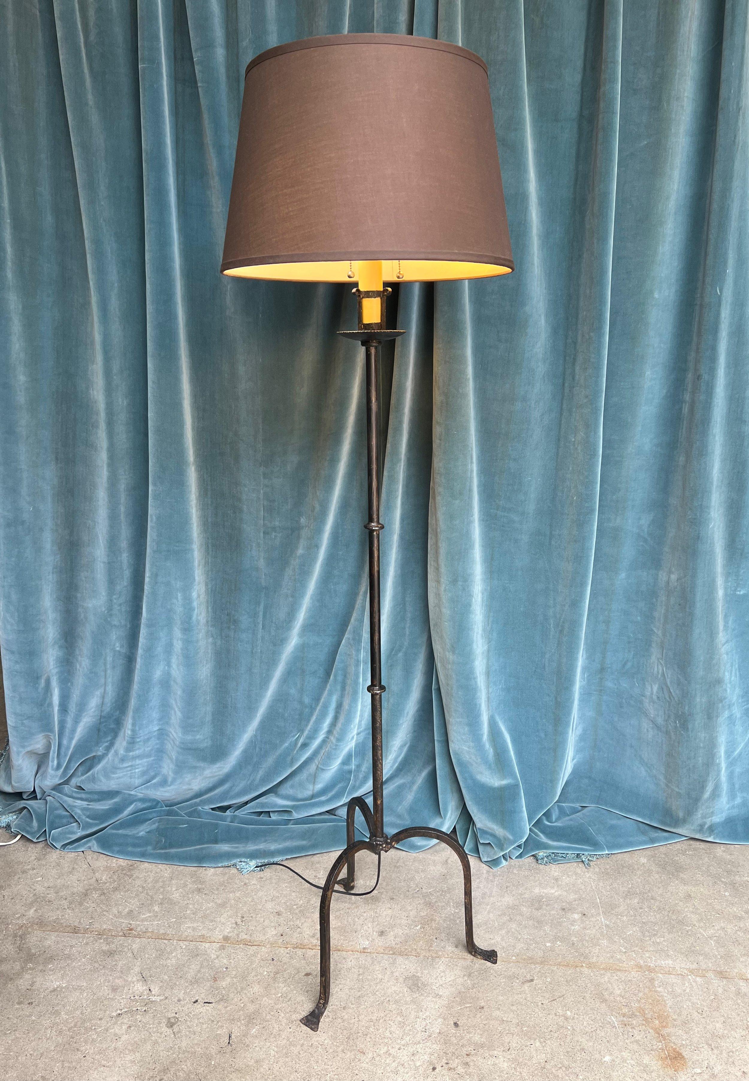 A unique and elegant mid-century modern Spanish iron floor lamp that seamlessly merges style and functionality. Handmade in the 1950s, this remarkable piece showcases excellent quality and timeless appeal. Measuring 64 inches high with a 16 inch