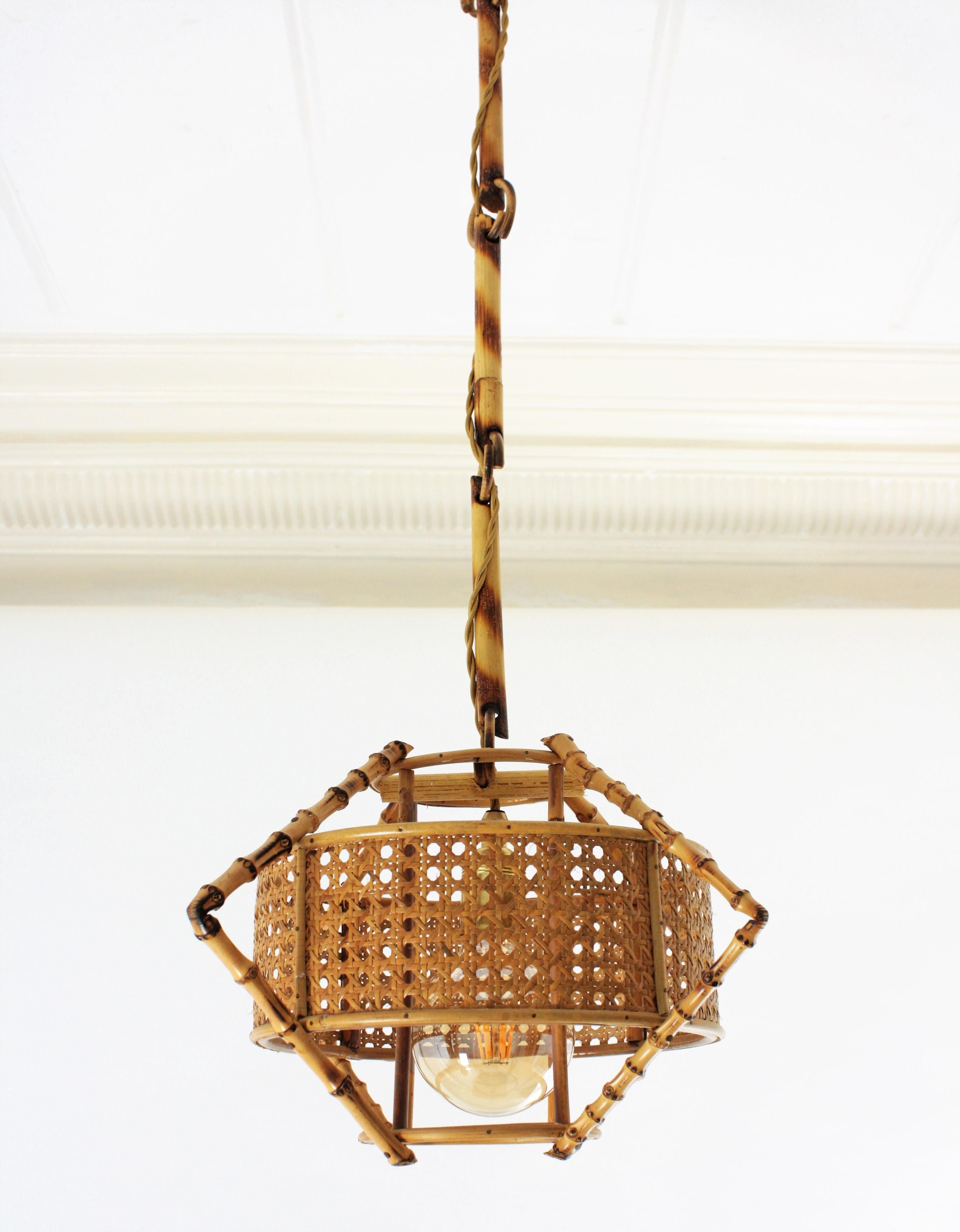 Unusual handcrafted bamboo and rattan hanging pendant lamp with a woven wicker shade. Manufactured at the Mid-Century Modern period with Tiki or oriental accents. Spain, 1950s.
This sculptural lamp combines a Midcentury taste at the woven wicker