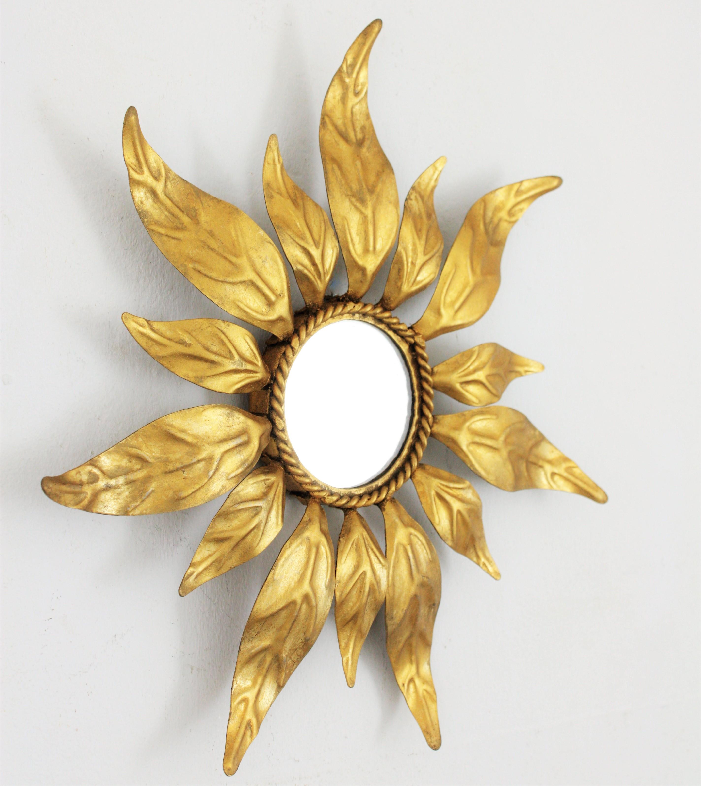 Lovely handcrafted gilt iron mini sunburst mirror with alternating leaves in two sizes and gold leaf finish. Unusual piecedue to its small size. Beautiful placed alone or creating a wall composition with other mini sized mirrors, Spain,